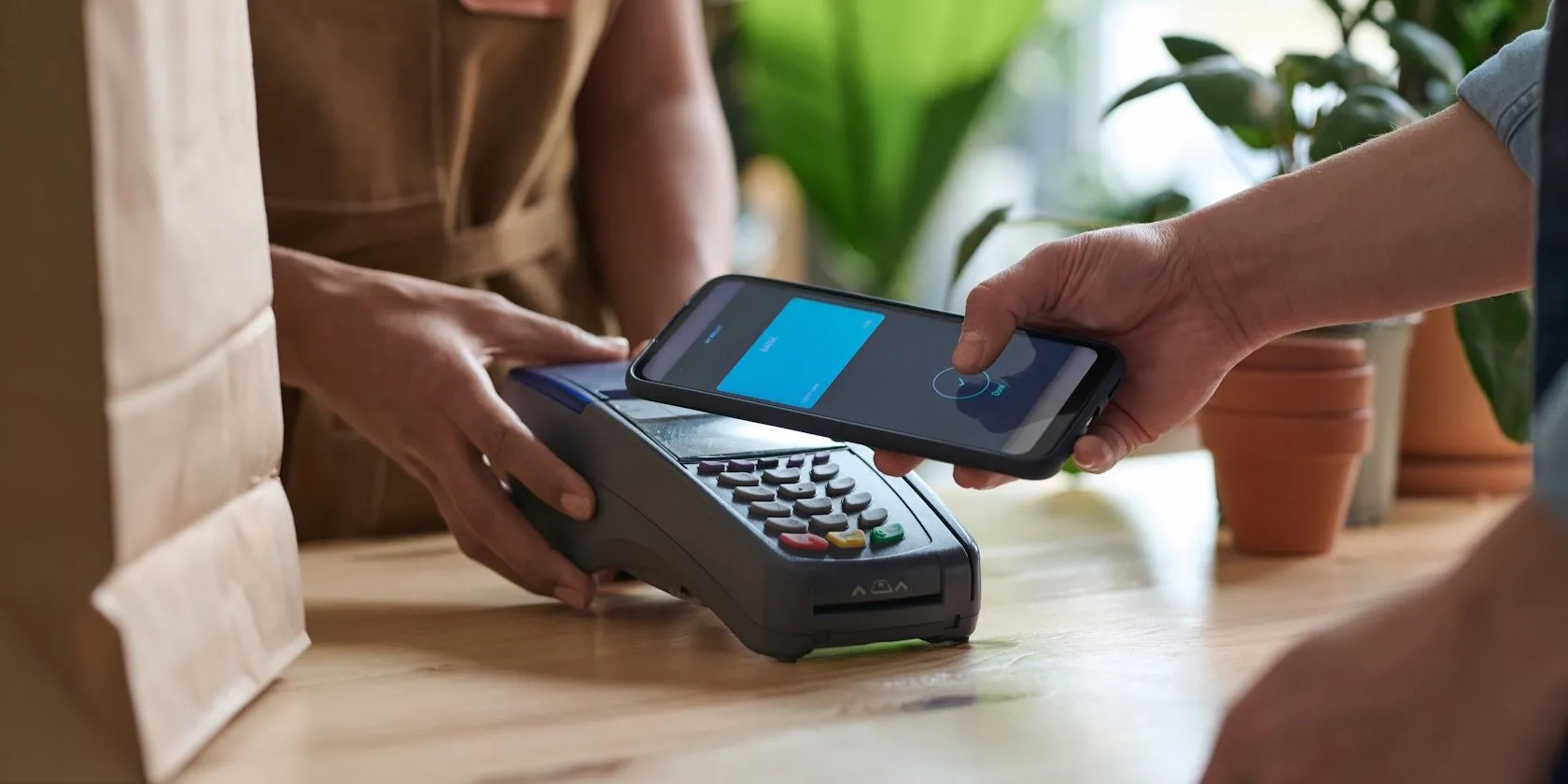 A guy making an NFC payment using his smartphone at a grocery store