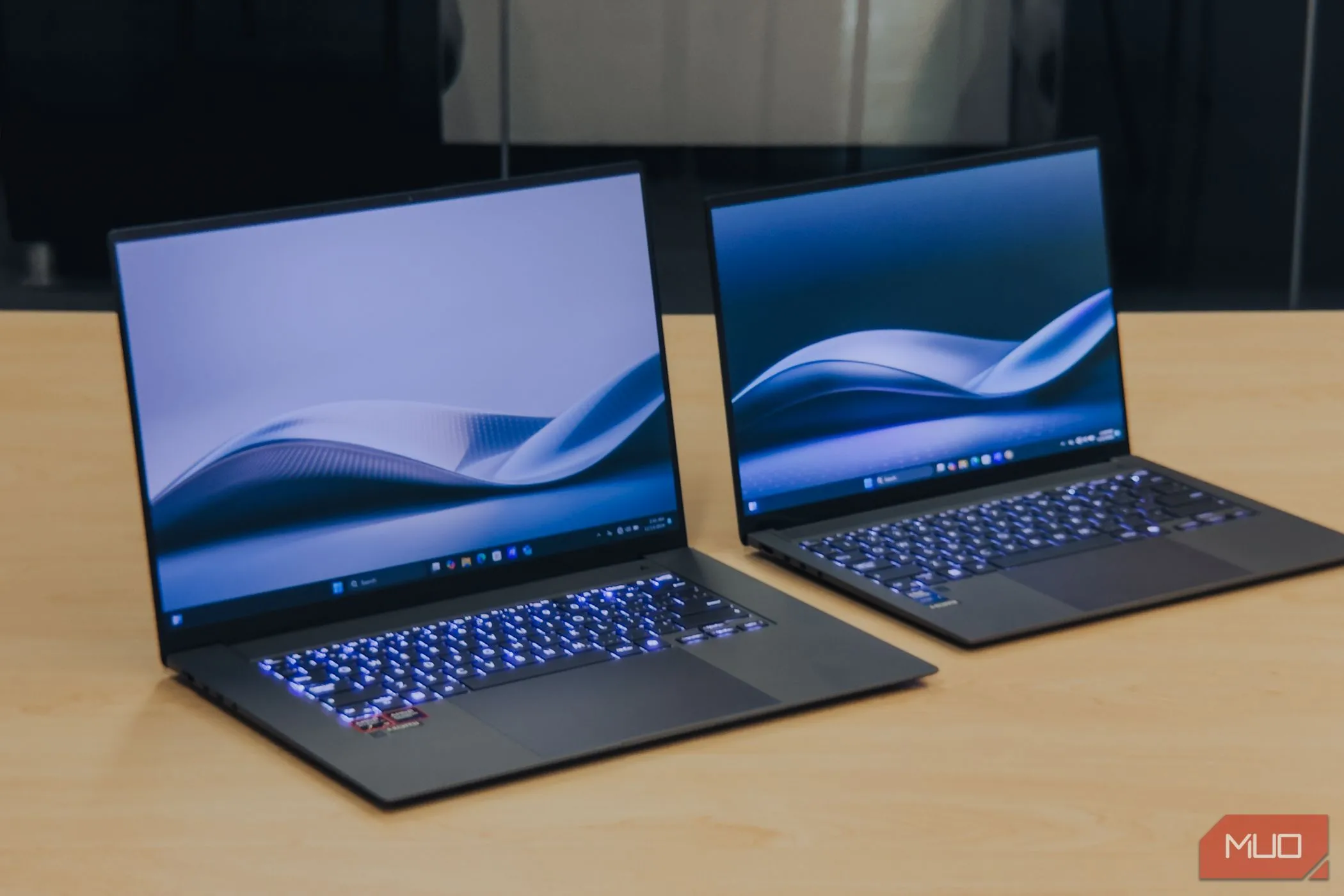 ASUS Zenbook S 16 OLED cạnh Zenbook S14 trên bàn gỗ