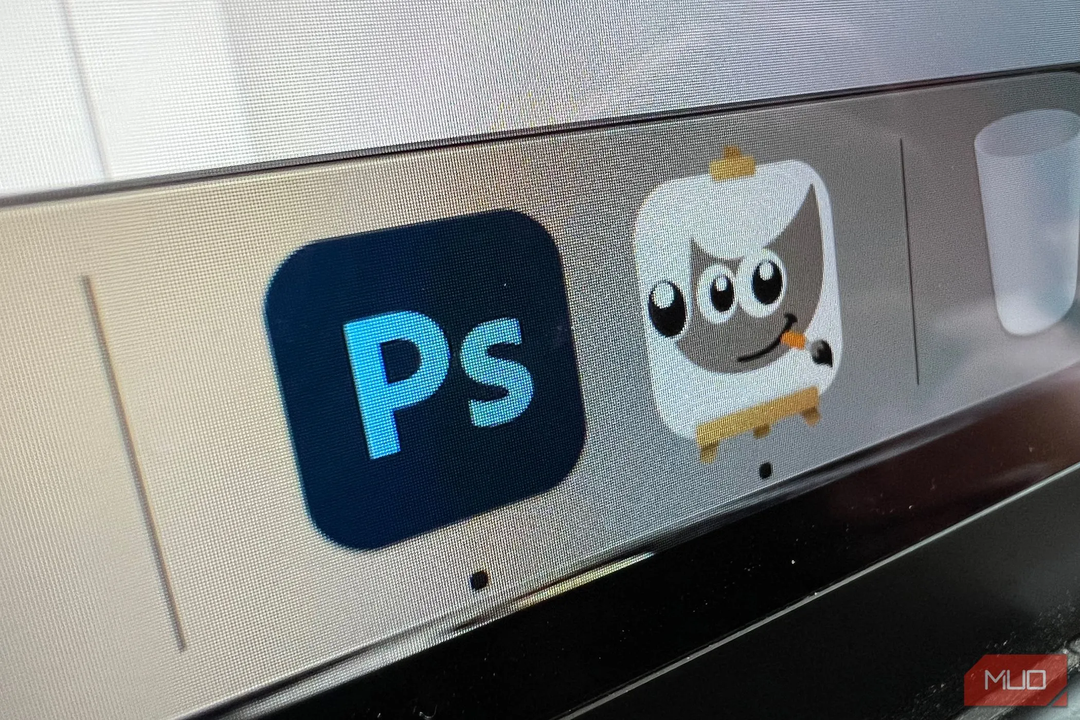 Biểu tượng GIMP và Photoshop trên MacBook, làm nổi bật sự khác biệt về chi phí và lựa chọn phần mềm.