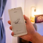 Boox Palma 2 màu đen với màn hình e-ink hiển thị giao diện chính, đang được cầm trong lòng bàn tay, minh họa thiết kế nhỏ gọn và tương tự smartphone.