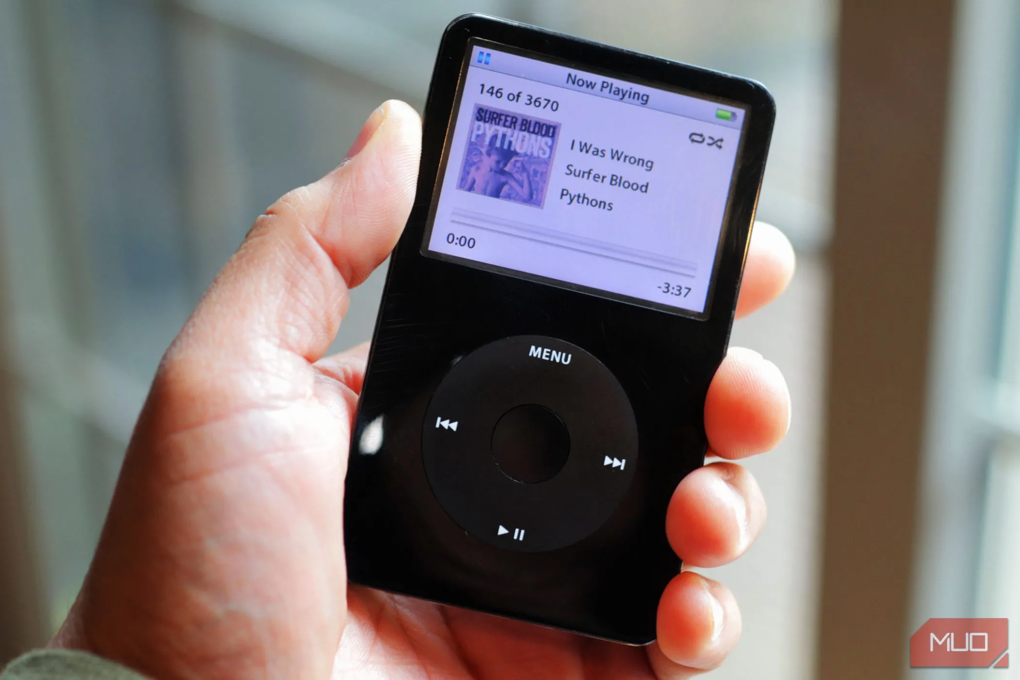 Chiếc iPod Classic màu đen cầm trên tay gần cửa sổ