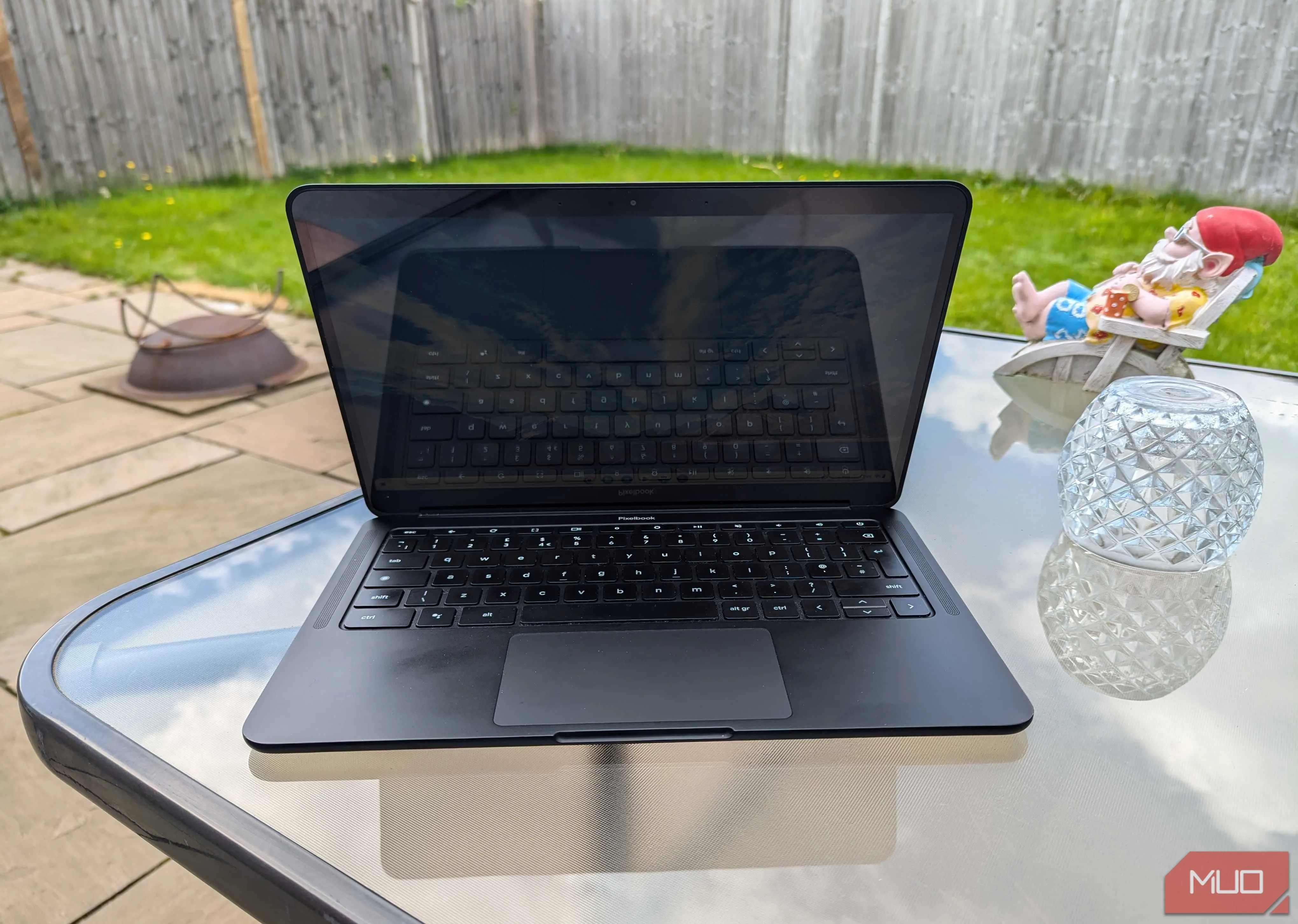 Chromebook đang mở trên bàn trong vườn, thể hiện khả năng khởi động nhanh chóng và sẵn sàng sử dụng mọi lúc mọi nơi