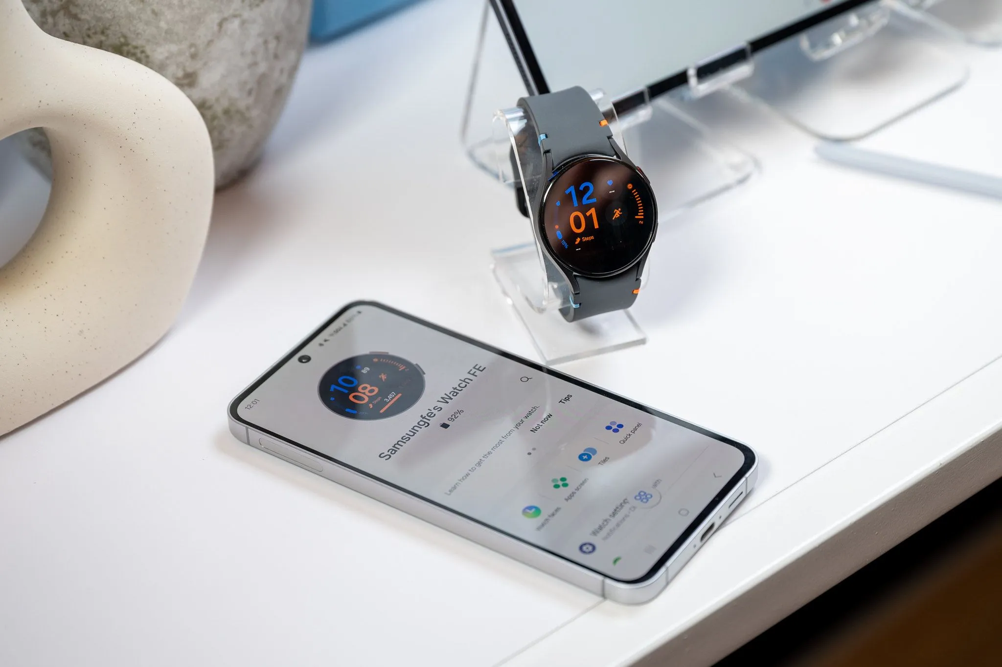 Điện thoại Samsung Galaxy S24 FE đang sạc cho đồng hồ Galaxy Watch LTE thông qua kết nối cáp USB-C, thể hiện khả năng sạc ngược của cổng USB.