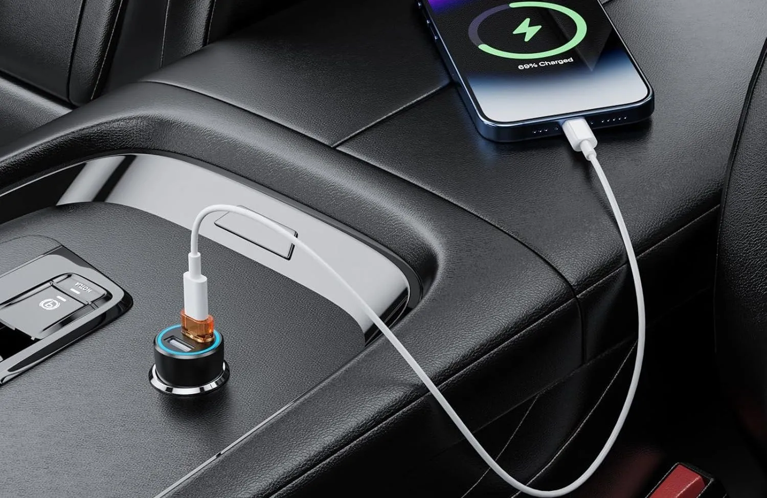 Điện thoại thông minh đang sạc trong ô tô qua cáp USB-C và bộ chuyển đổi USB-A sang USB-C cắm vào cổng USB của xe.