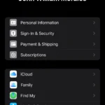 Giao diện cài đặt hồ sơ iPhone hiển thị thông tin tài khoản Apple ID chính và tài khoản phụ trong mục Phương tiện & Mục mua để chuẩn bị chuyển đổi ứng dụng.