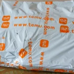 Gói hàng Temu được đặt trên bàn, minh họa cho việc mua sắm trực tuyến bị ảnh hưởng bởi chính sách thuế quan mới.