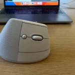 Hình ảnh chuột không dây Logitech Lift màu trắng đặt gần màn hình laptop, tối ưu cho làm việc từ xa