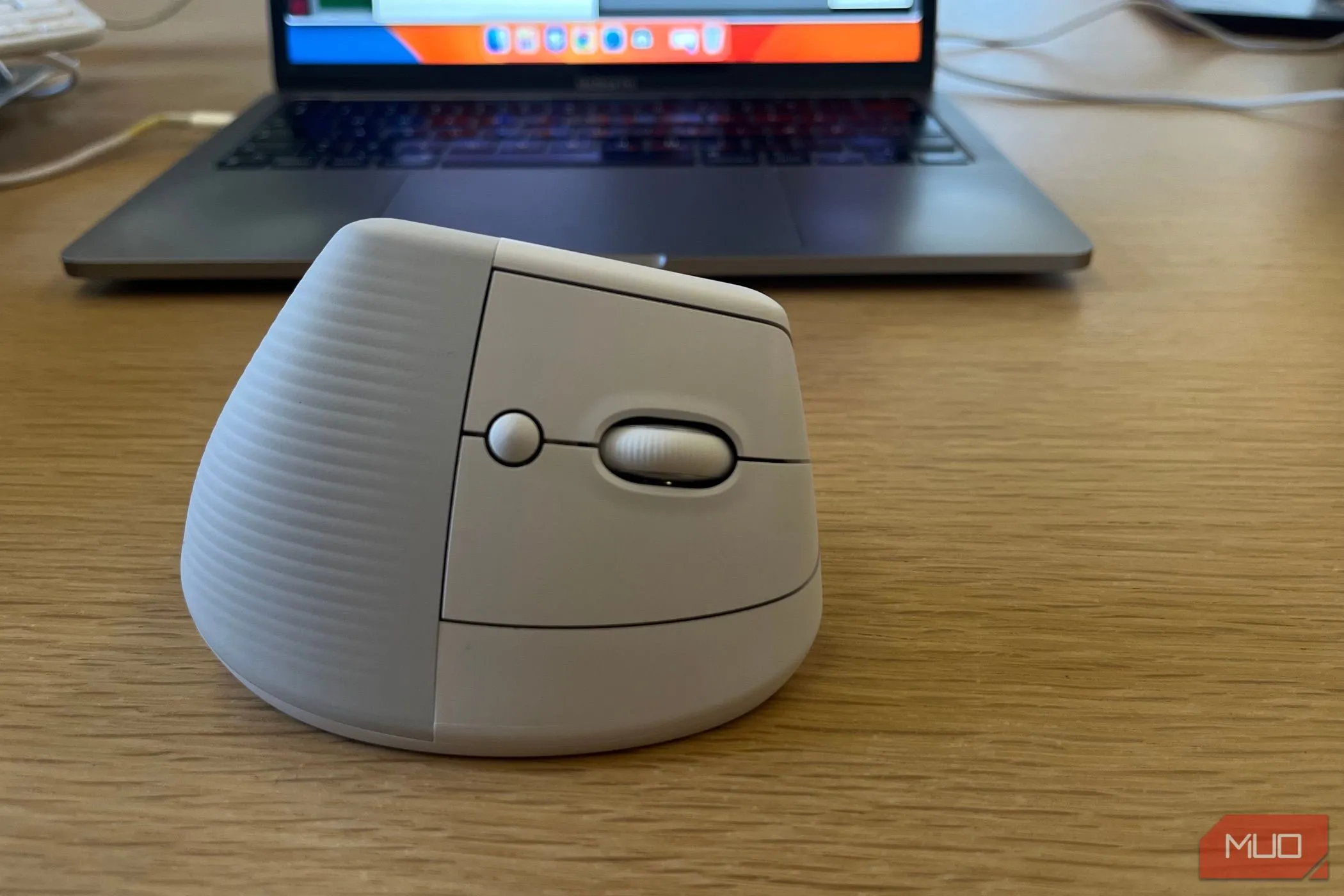 Hình ảnh chuột không dây Logitech Lift màu trắng đặt gần màn hình laptop, tối ưu cho làm việc từ xa