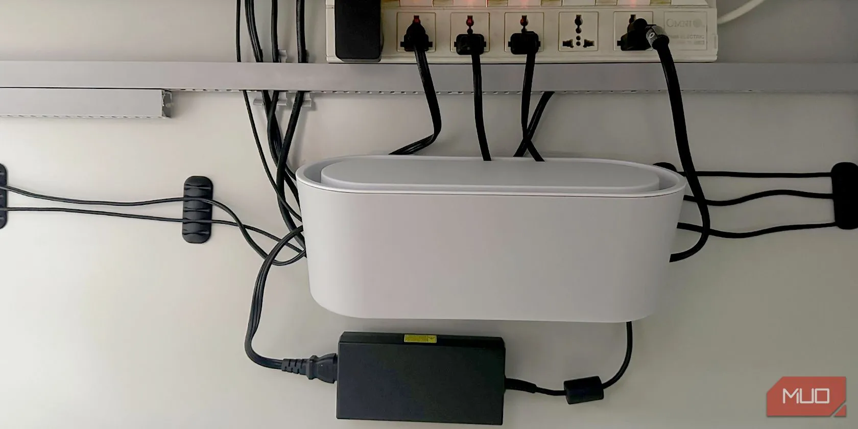 Hộp cáp và ổ cắm điện nối dài, minh họa việc không nên cắm powerline adapter vào ổ cắm phụ hoặc chống sét lan truyền để duy trì hiệu suất.
