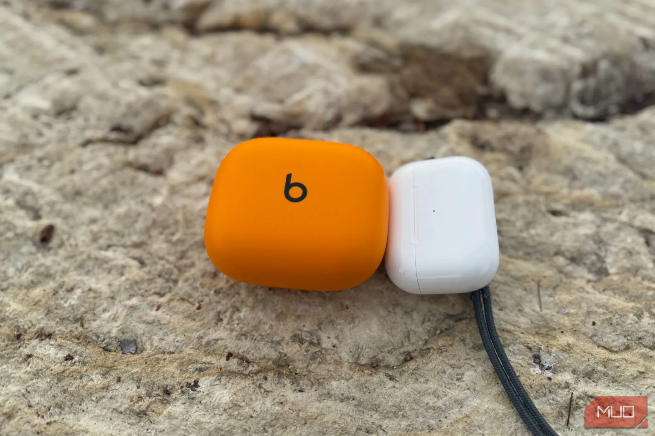 Hộp sạc AirPods Pro 2 nhỏ gọn bên cạnh hộp sạc Powerbeats Pro 2 cồng kềnh hơn.
