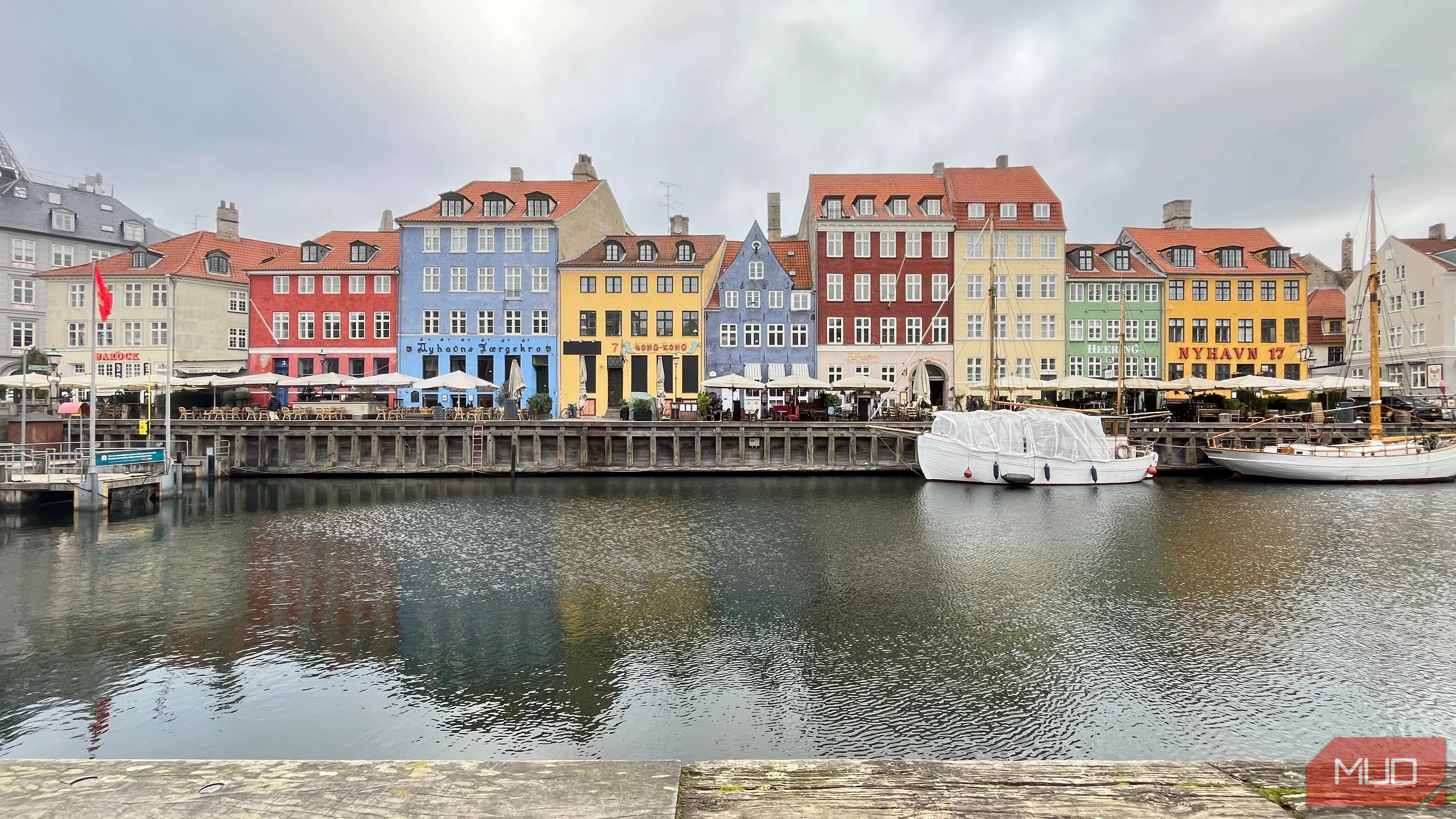 Kênh đào Nyhavn với những ngôi nhà nhiều màu sắc và hình ảnh phản chiếu trên mặt nước, chụp từ góc thấp.