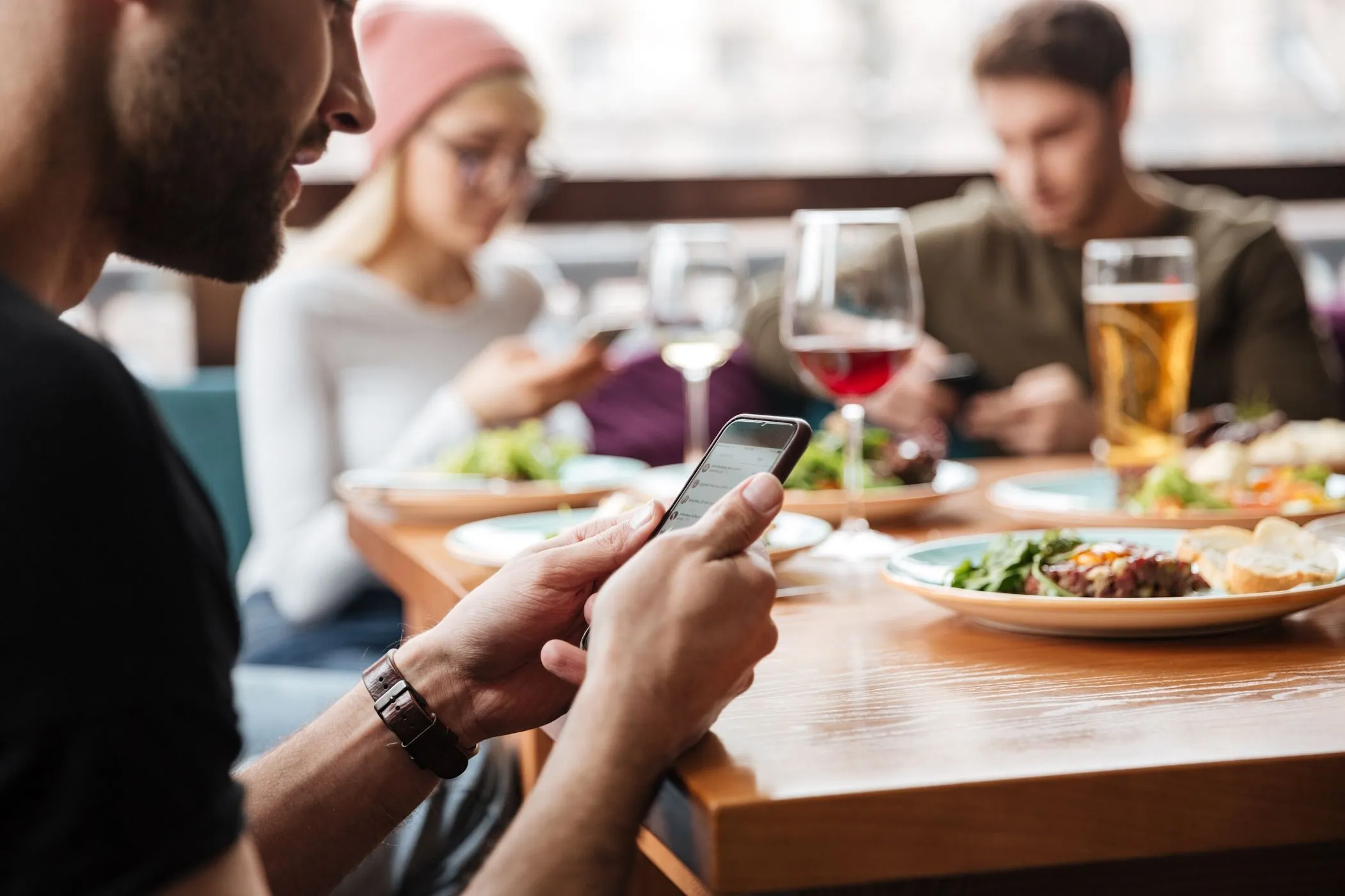 Khách du lịch đang dùng điện thoại kiểm tra Wi-Fi trong quán cà phê