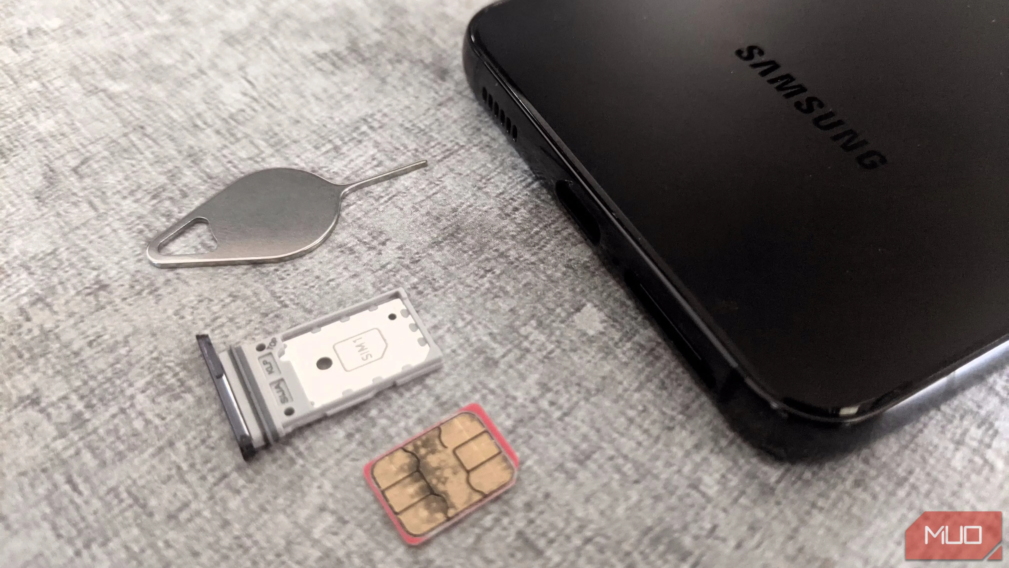 Khay SIM và điện thoại Samsung cùng công cụ đẩy SIM trên bề mặt phẳng
