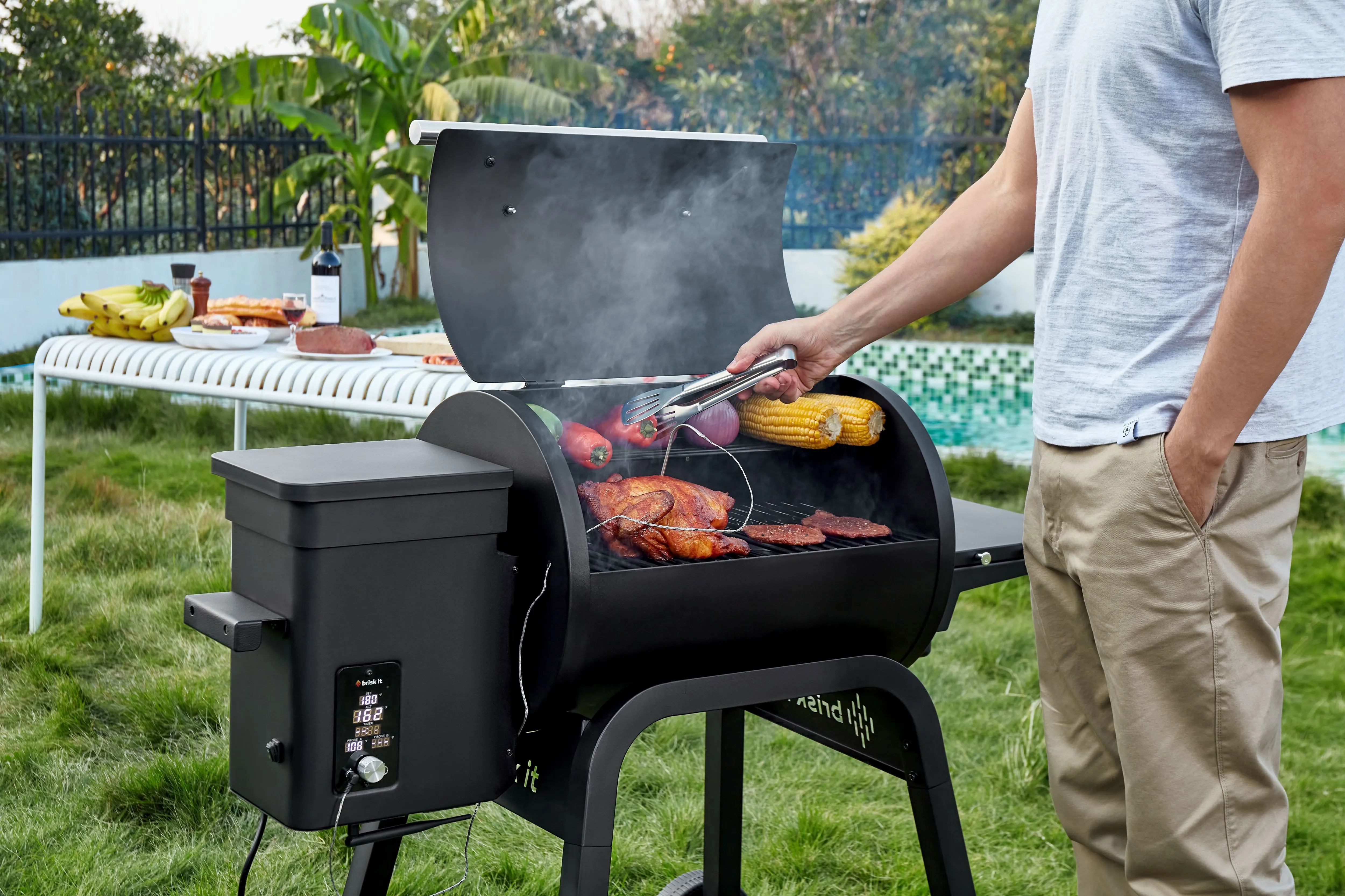 Lò nướng thông minh Brisk It Zelos-450 đang nướng BBQ ngoài trời, tỏa khói nhẹ.
