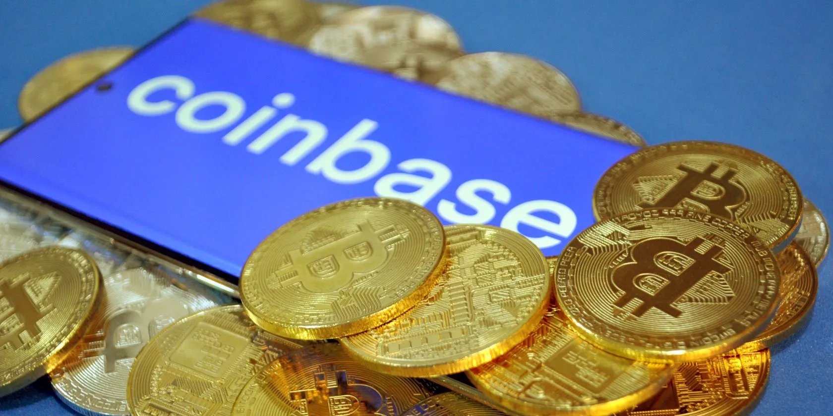 Logo Coinbase với các đồng Bitcoin bao quanh, minh họa sự cố rò rỉ dữ liệu cá nhân trên sàn giao dịch tiền điện tử.