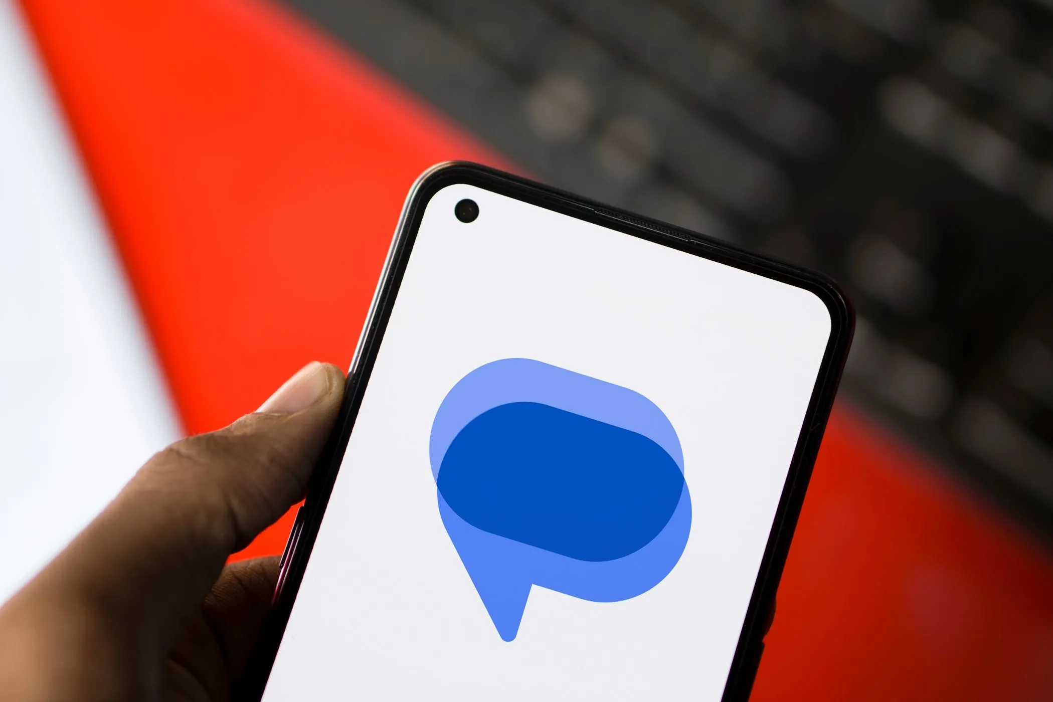 Logo Google Messages hiển thị trên màn hình điện thoại Android với bàn phím ảo phía sau, minh họa tính năng cảnh báo ảnh nhạy cảm của SafetyCore.