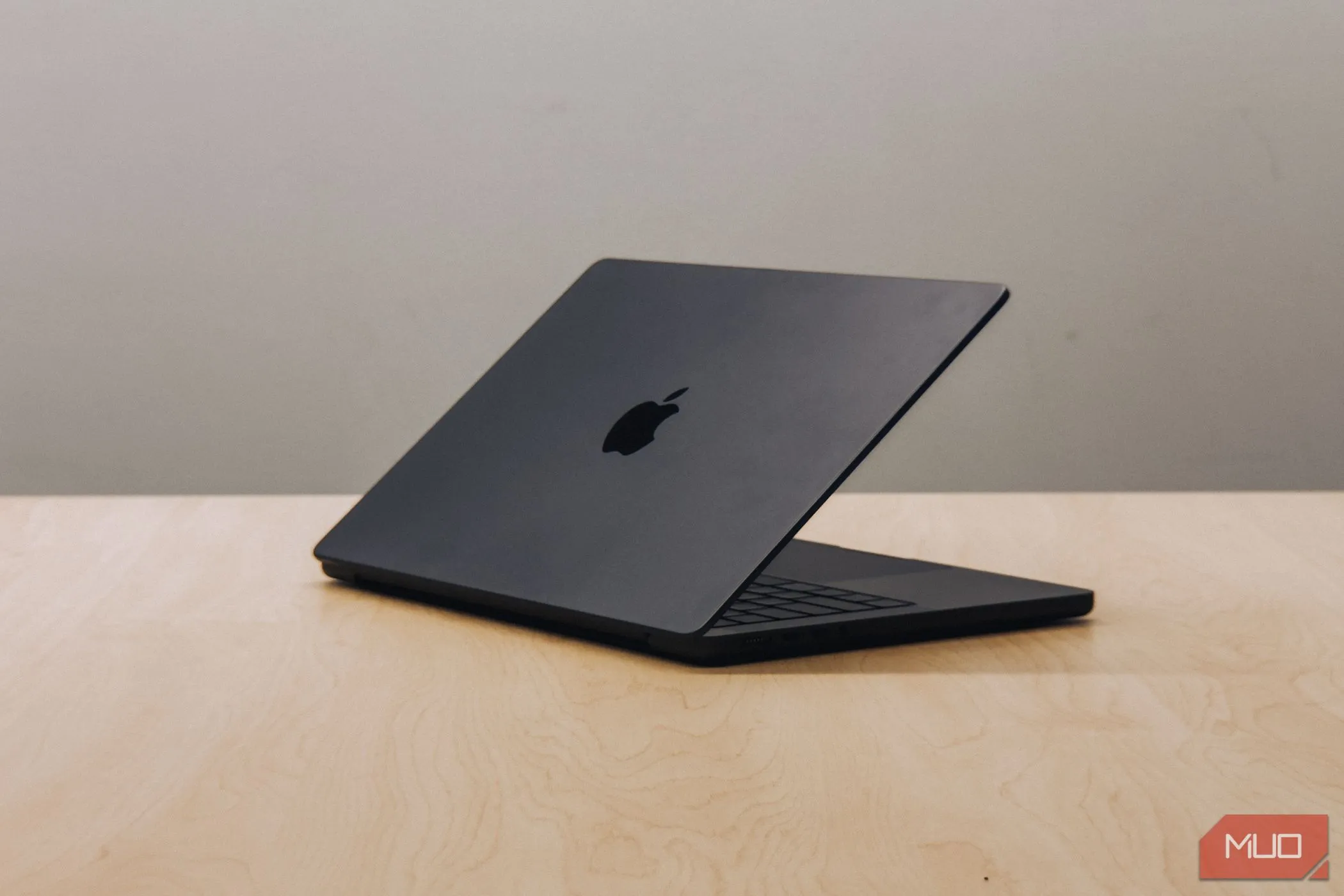 MacBook Pro M4 với màn hình gập xuống trên bàn gỗ, minh họa cho sự chuyển đổi của Apple sang chip Silicon và sự cần thiết nâng cấp thiết bị Mac.