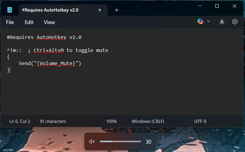 Màn hình máy tính hiển thị script AutoHotkey để tắt tiếng hệ thống nhanh chóng và biểu tượng âm thanh đang bị tắt.