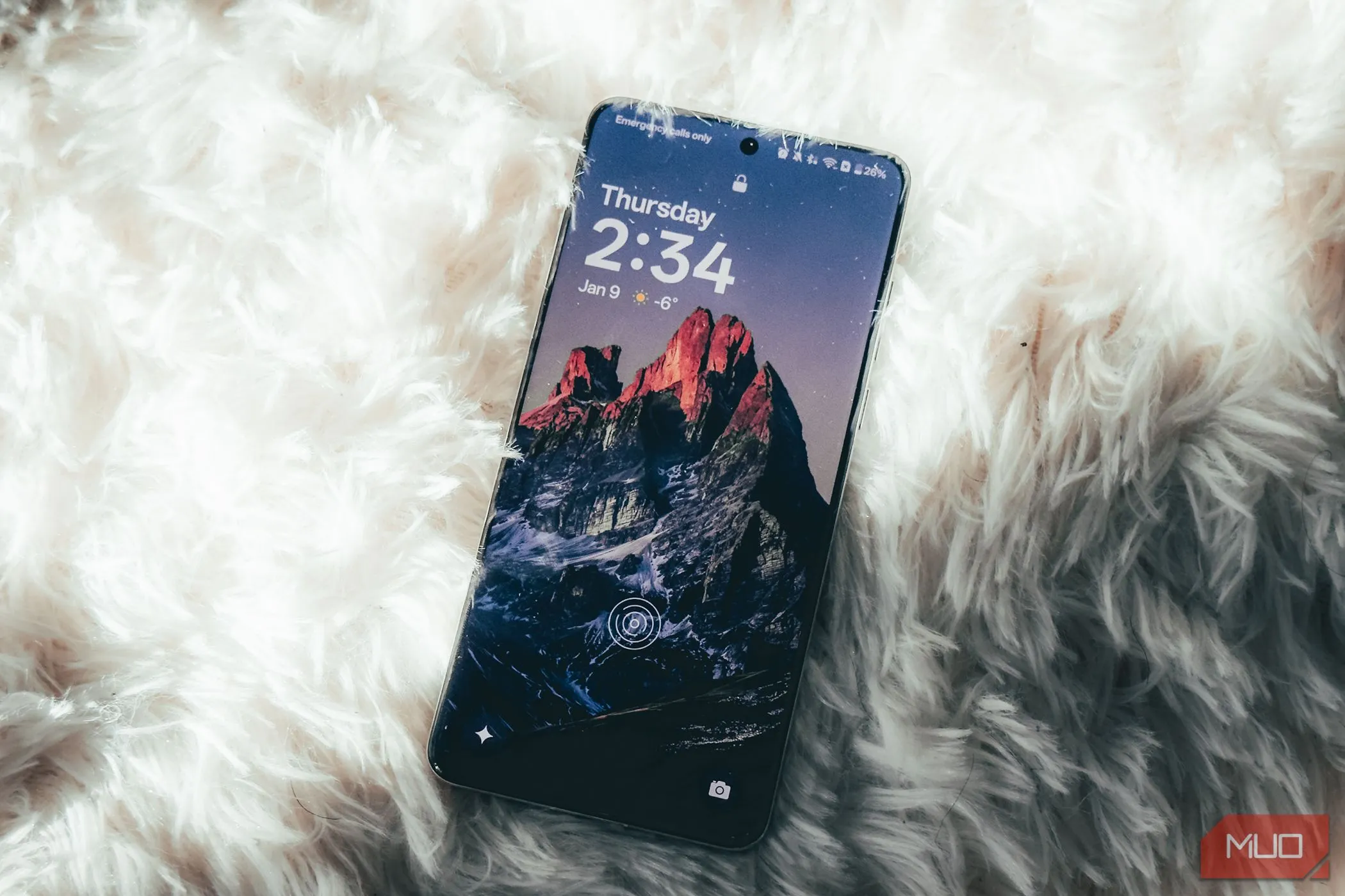 Màn hình OnePlus 13 hiển thị nội dung trên bề mặt thảm trắng