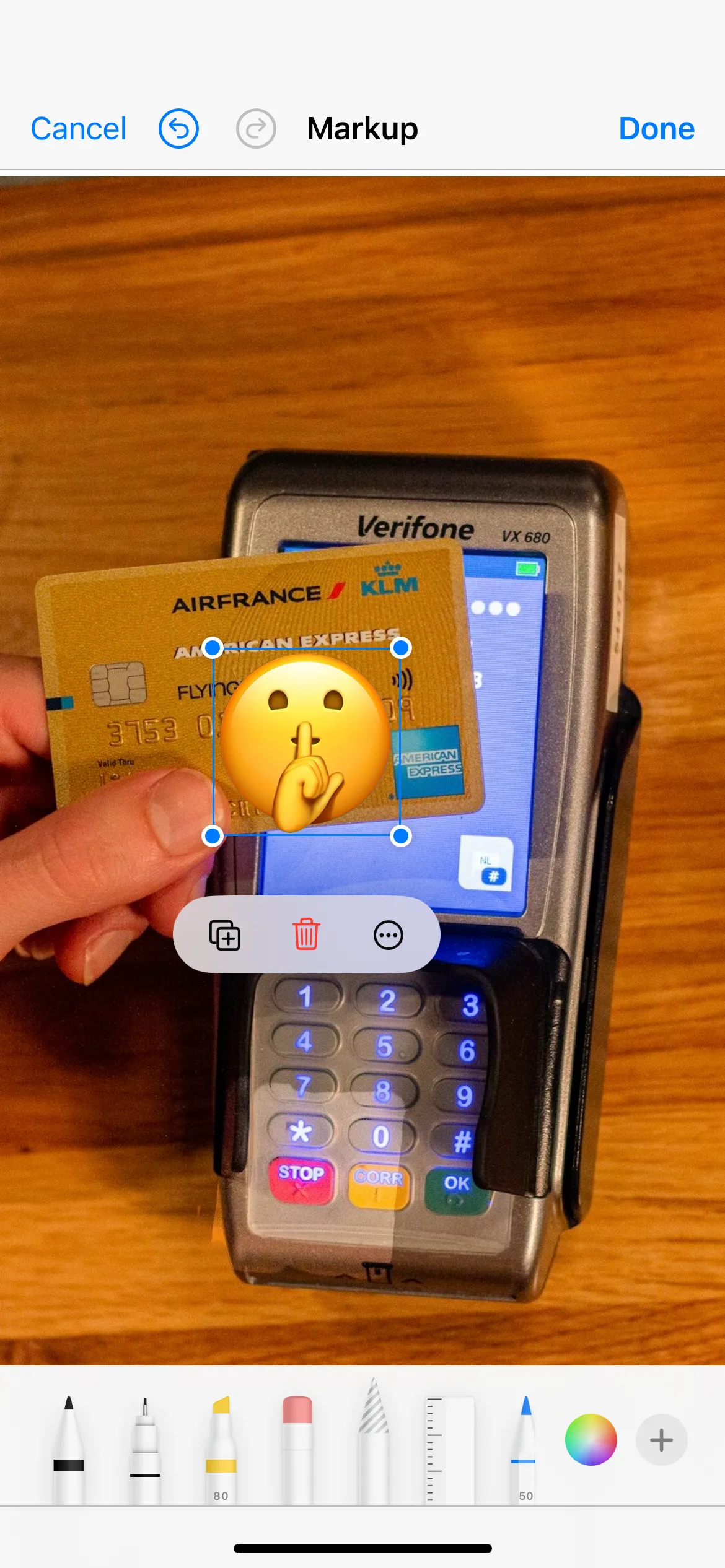 Markup tool in iPhone Photos app showing an image of credit card with numbers covered with an emoji