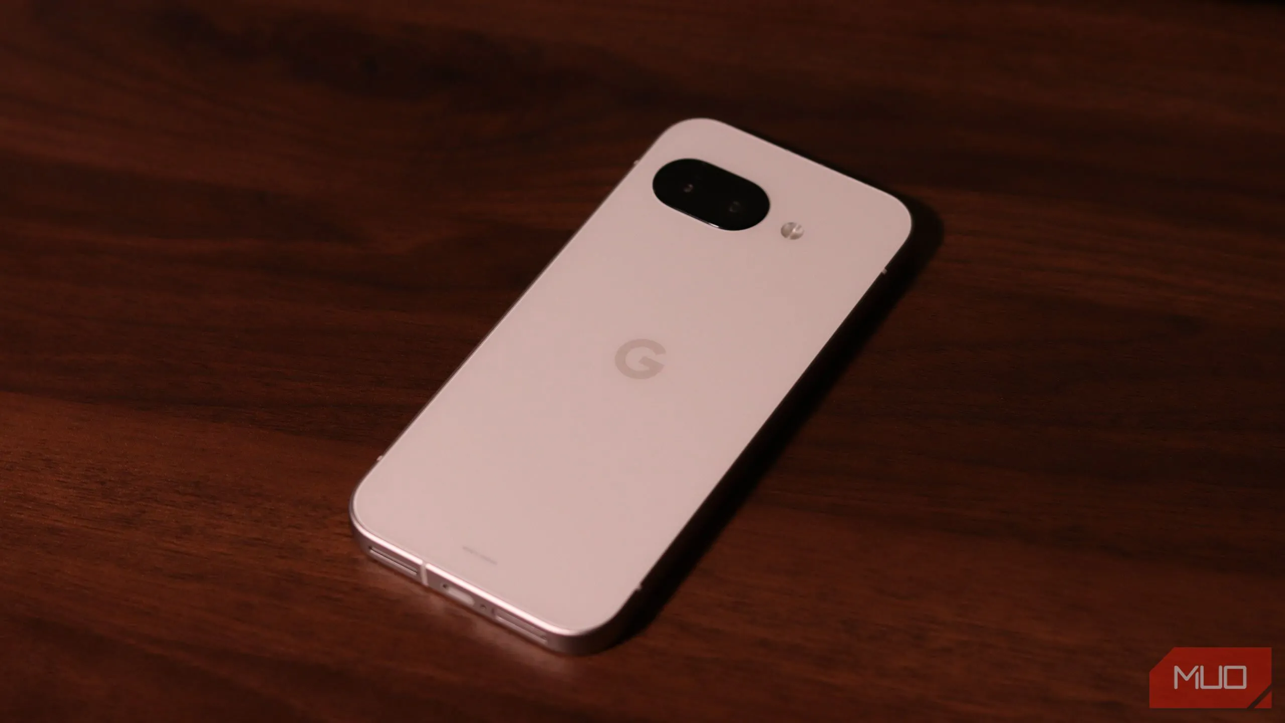 Mặt lưng điện thoại Google Pixel 9a với thanh camera đặc trưng đặt trên bề mặt gỗ