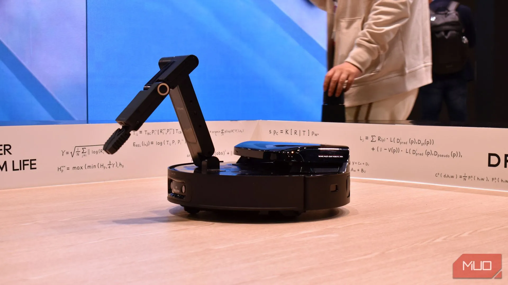 Mẫu thử nghiệm robot hút bụi của Dreame với cánh tay robot gắp đồ vật tại sự kiện CES 2025, cho thấy tầm nhìn tương lai của việc dọn dẹp tự động.