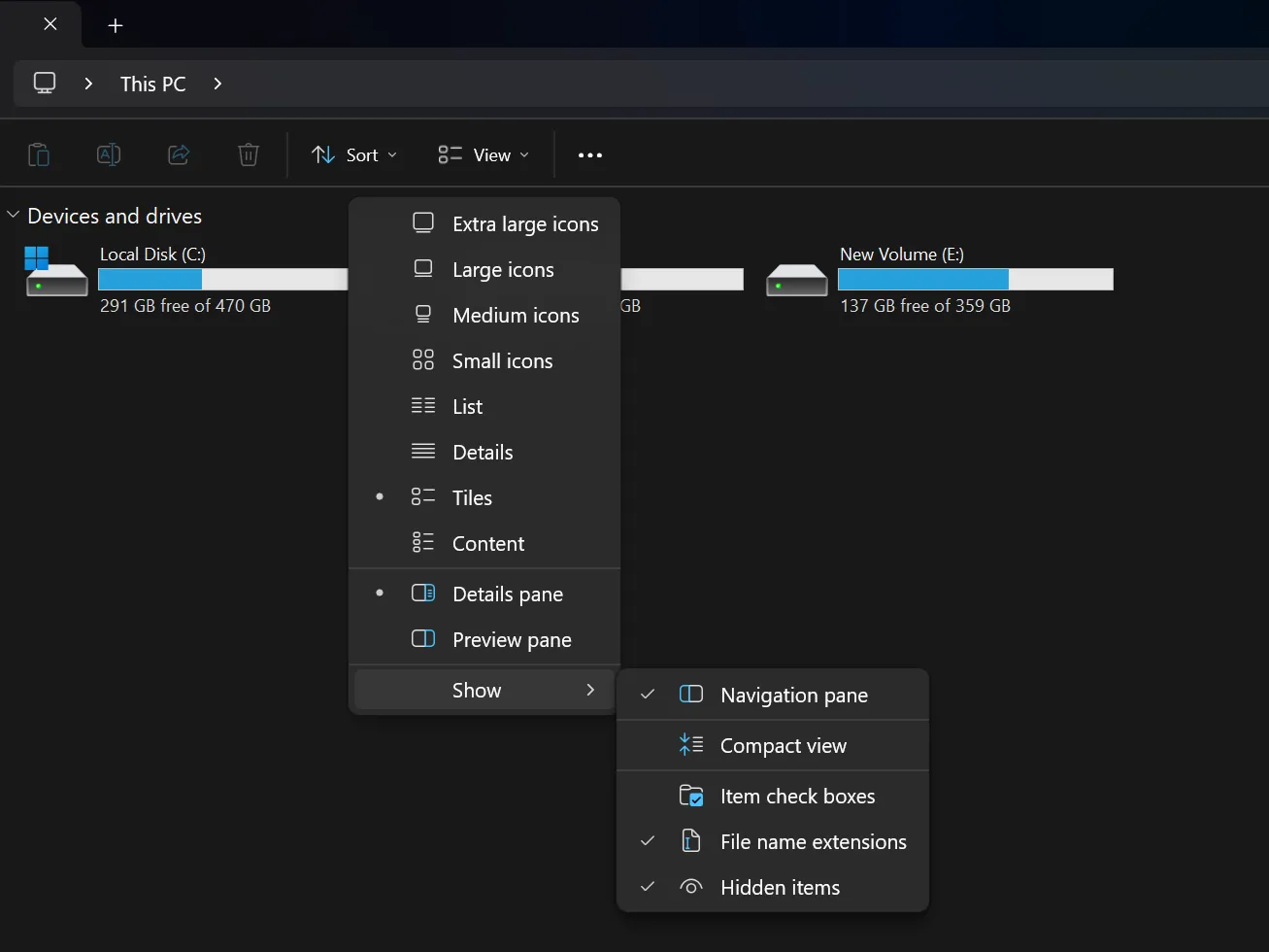 Menu View hiển thị tùy chọn 'File name extensions' đã được bật, với các phân vùng ổ đĩa ở chế độ nền