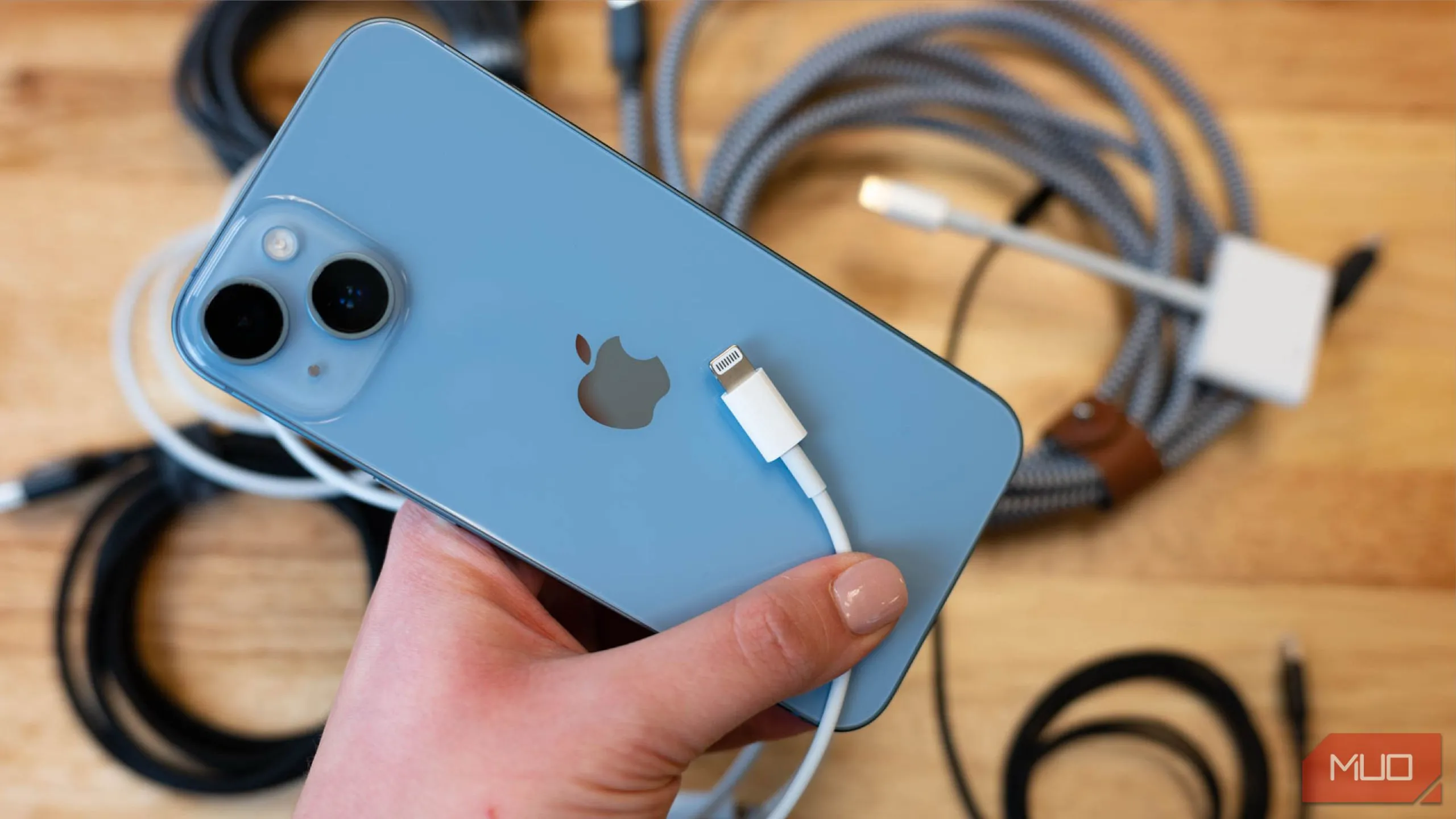 Một chiếc iPhone 13 đặt cạnh cáp sạc Lightning, tượng trưng cho thói quen sạc pin hàng ngày và sự tiện lợi của sạc nhanh