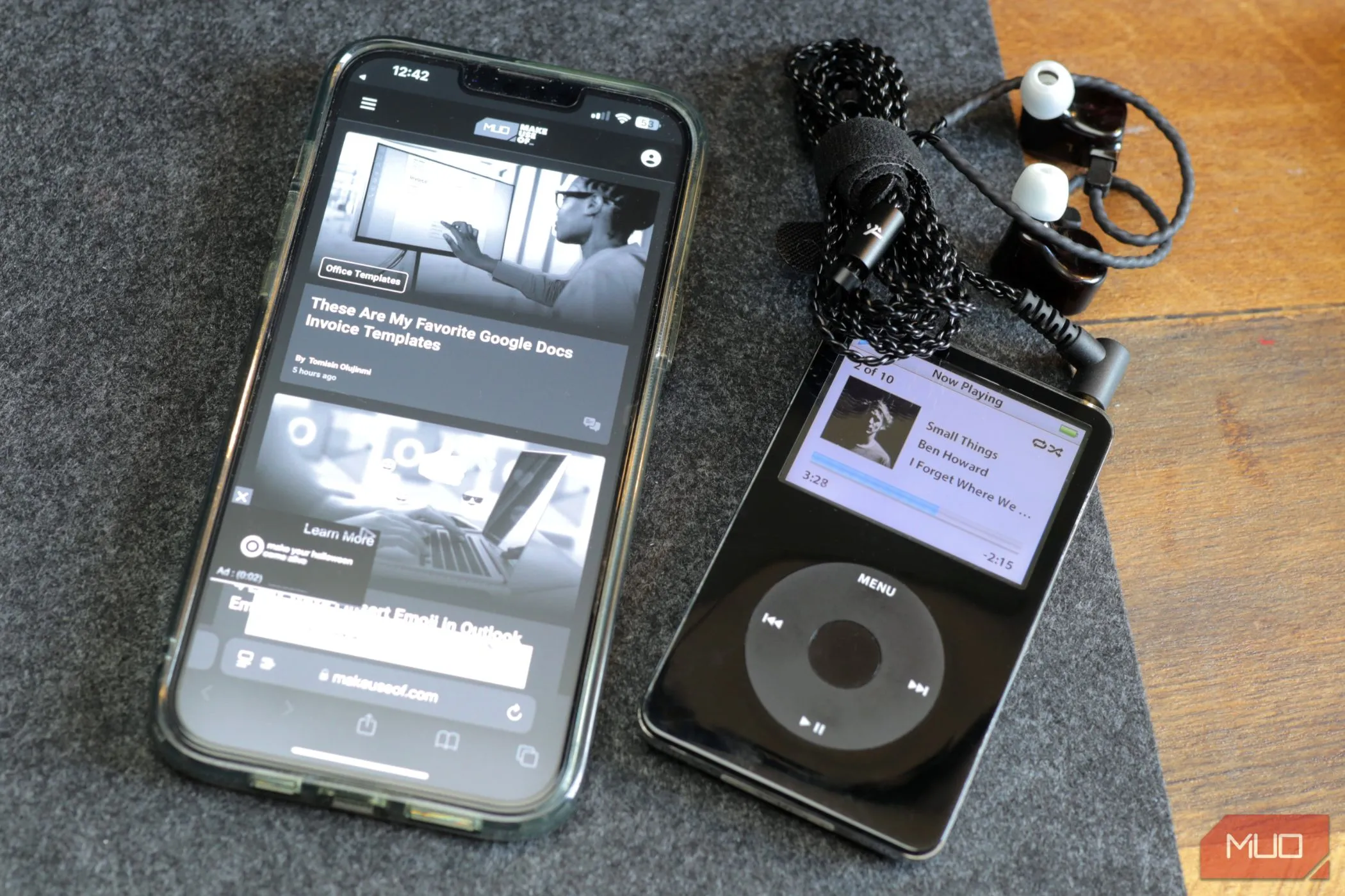 Một chiếc iPod đen và iPhone 13 trắng đen trên tấm lót bàn bằng nỉ