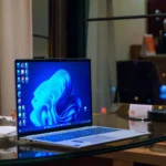 Một chiếc laptop chạy Windows 11 hiển thị hình mờ cảnh báo trên màn hình desktop, minh họa chính sách mới của Microsoft.