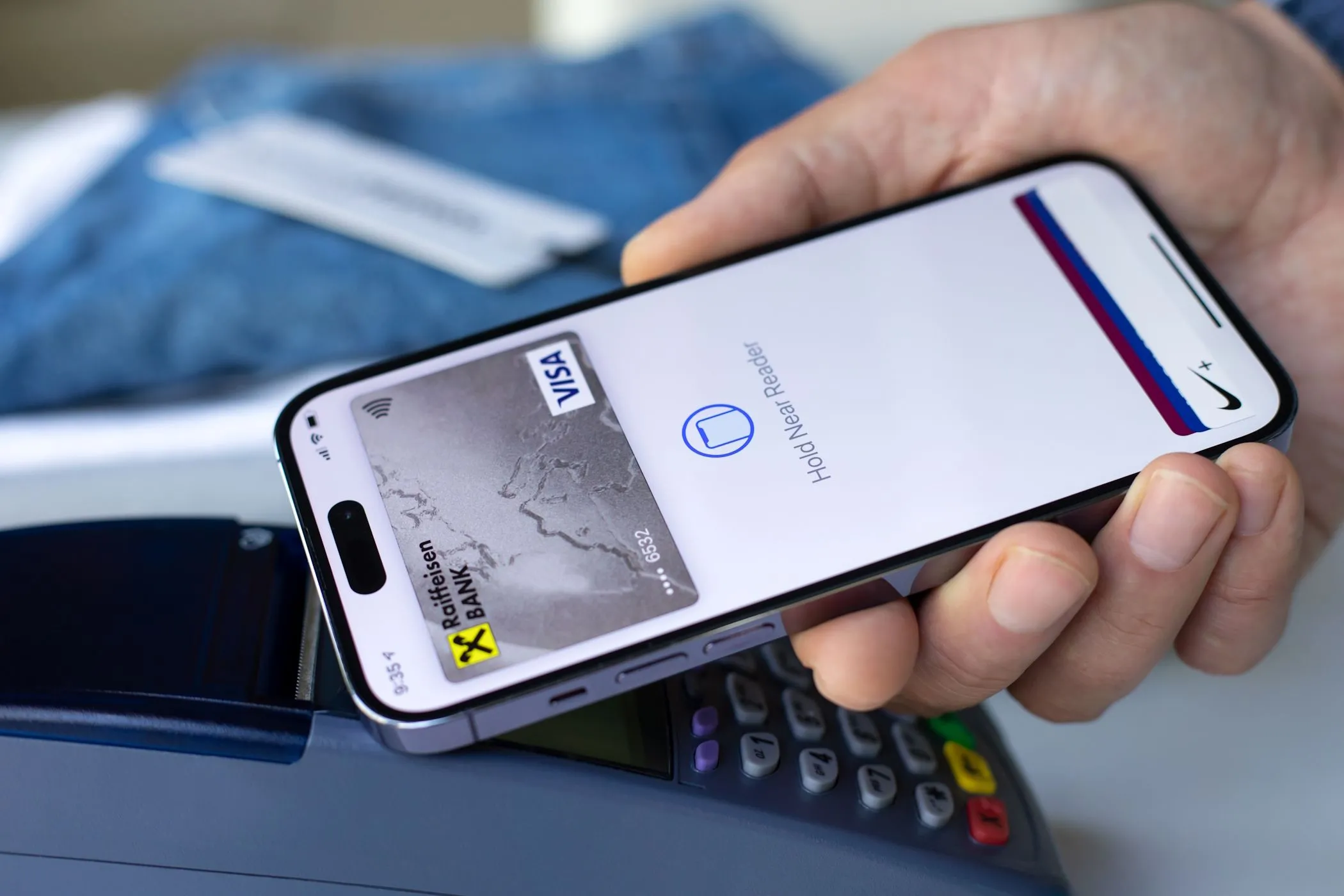 Một người đàn ông đang sử dụng Apple Pay trên iPhone để thanh toán tại cửa hàng