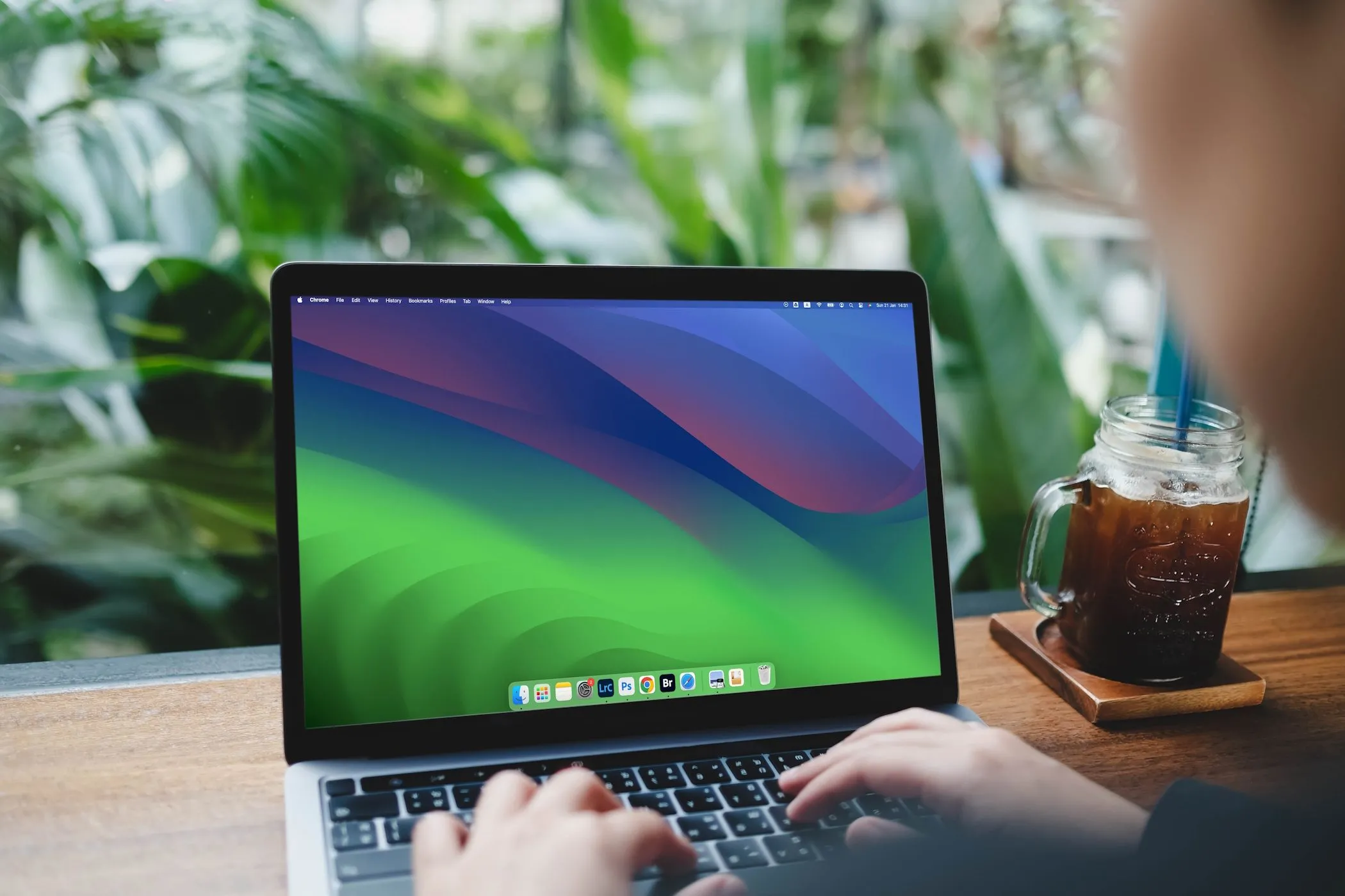Một phụ nữ đang gõ bàn phím trên MacBook Air chạy macOS Sonoma, tượng trưng cho việc nghiên cứu kỹ lưỡng các thông tin về công ty và dự án