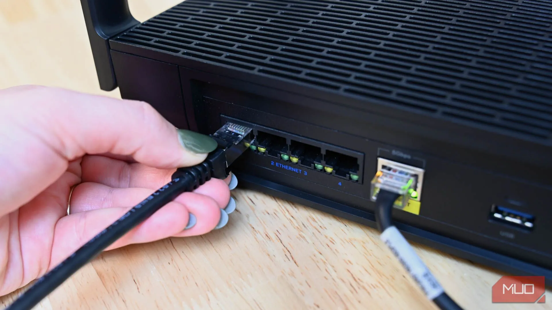 Người cắm cáp Ethernet vào router du lịch hoặc cổng mạng, biểu thị kết nối có dây