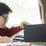 Người đàn ông đang kiểm tra máy in trên bàn làm việc