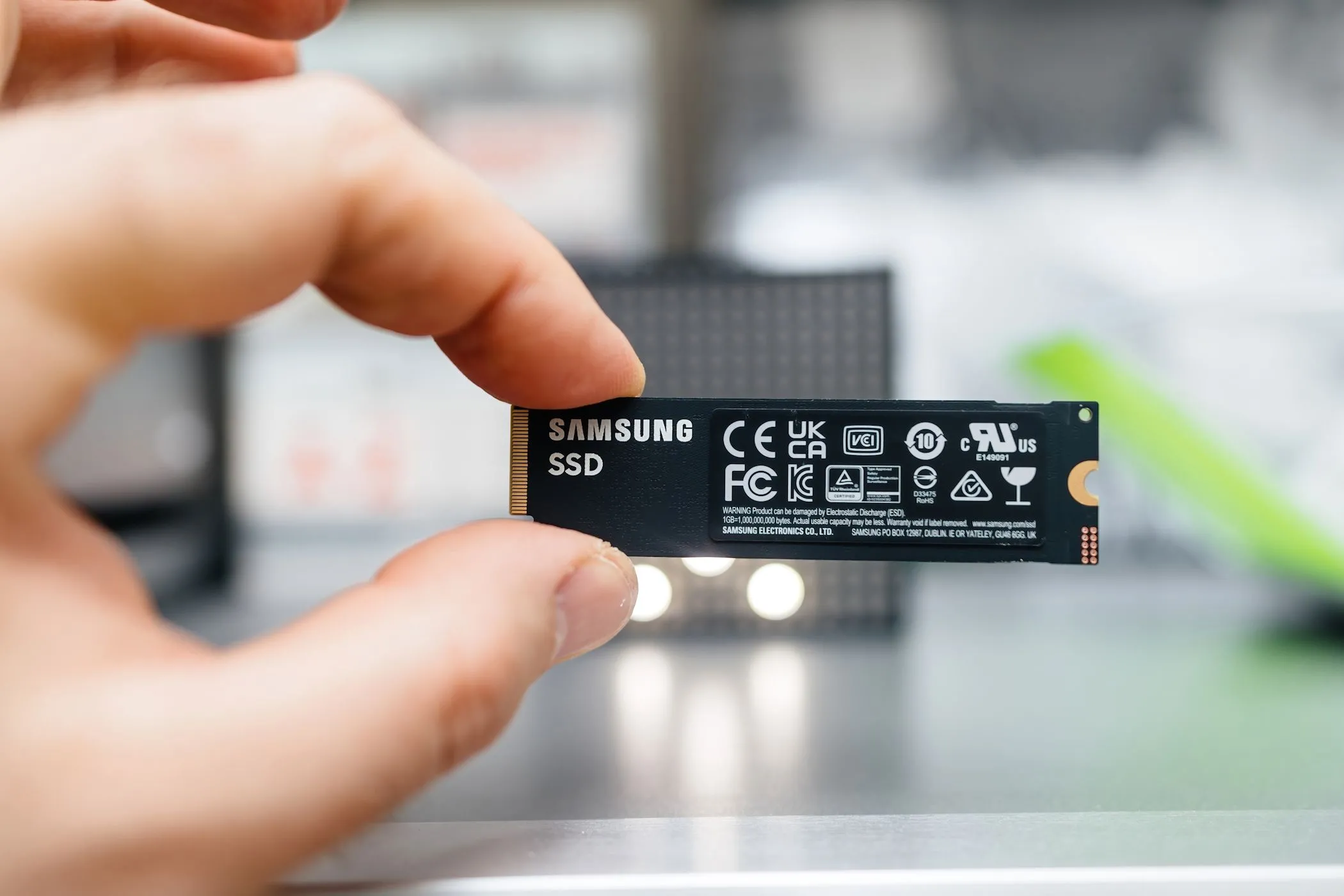 Người dùng cầm ổ đĩa SSD Samsung nhỏ gọn, minh họa sự tiện lợi và giá cả phải chăng của các ổ đĩa dung lượng cao hiện nay.