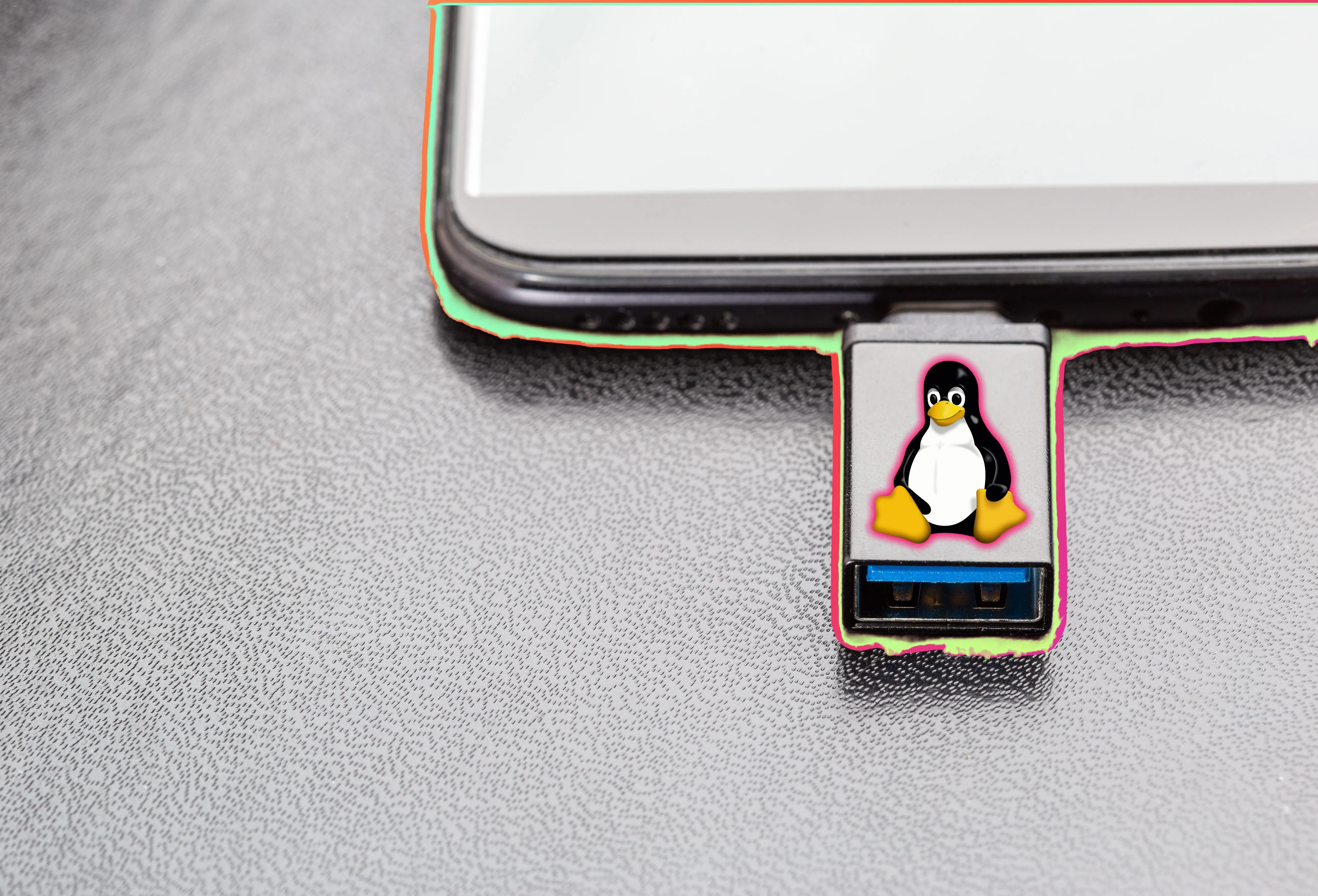 Người dùng cắm USB cứu hộ Linux có logo Tux vào laptop