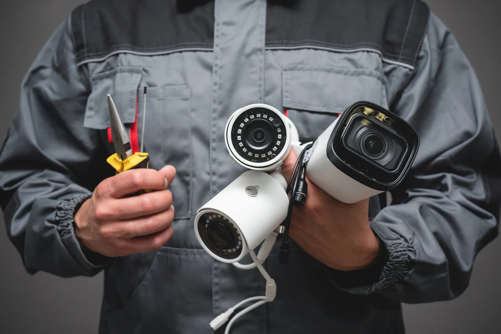 Người dùng đang cầm các thiết bị camera an ninh, tượng trưng cho việc smart TV thu thập dữ liệu cá nhân một cách tinh vi.