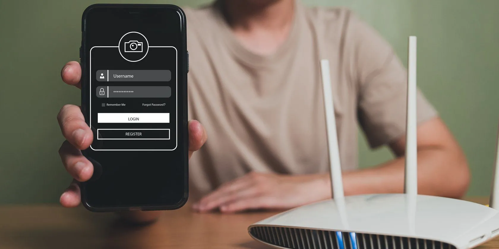 Người dùng đang giữ điện thoại di động gần router Wi-Fi, minh họa việc thiết lập mạng khách.