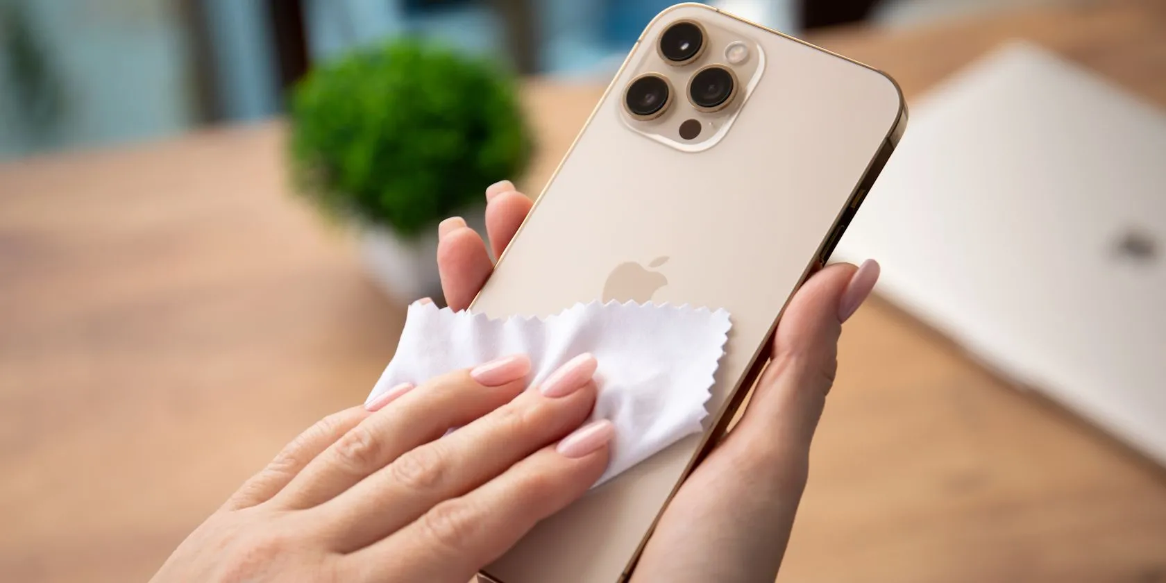 Người phụ nữ đang làm sạch màn hình iPhone bằng khăn microfiber