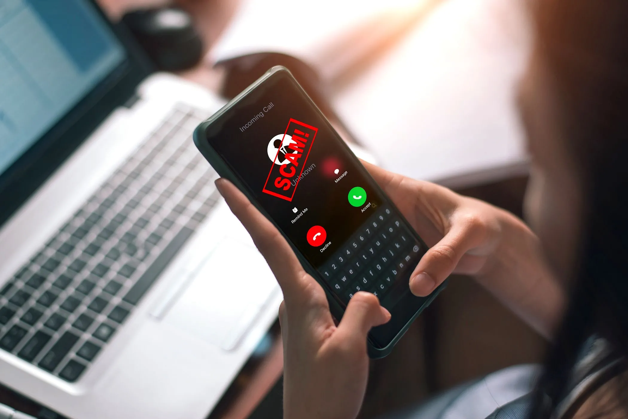 Người phụ nữ đang trả lời điện thoại di động hiển thị cảnh báo cuộc gọi lừa đảo tiềm năng