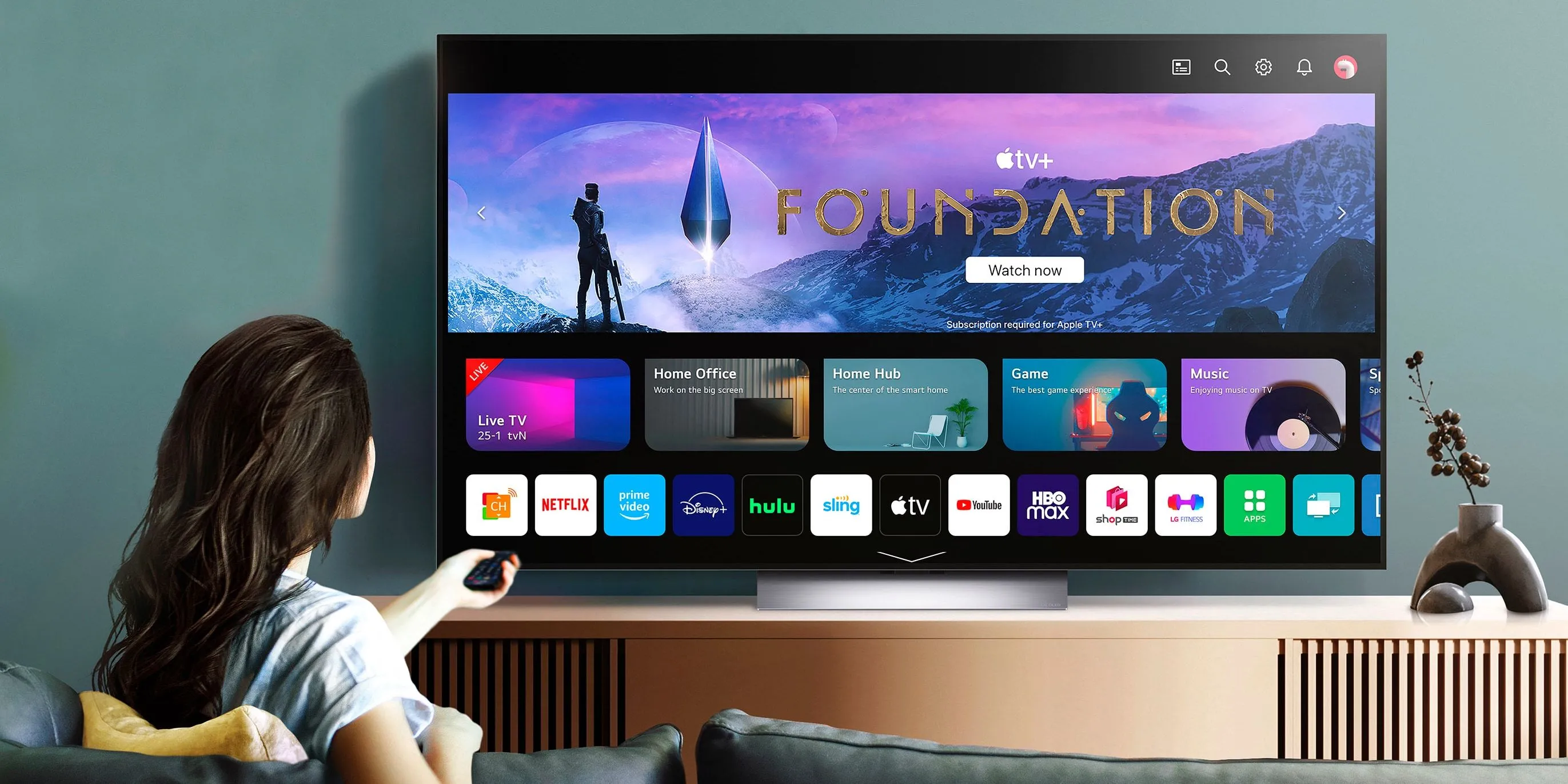 Người phụ nữ trải nghiệm TV LG OLED Evo với hình ảnh sắc nét, màu đen sâu khi xem phim trên Apple TV+