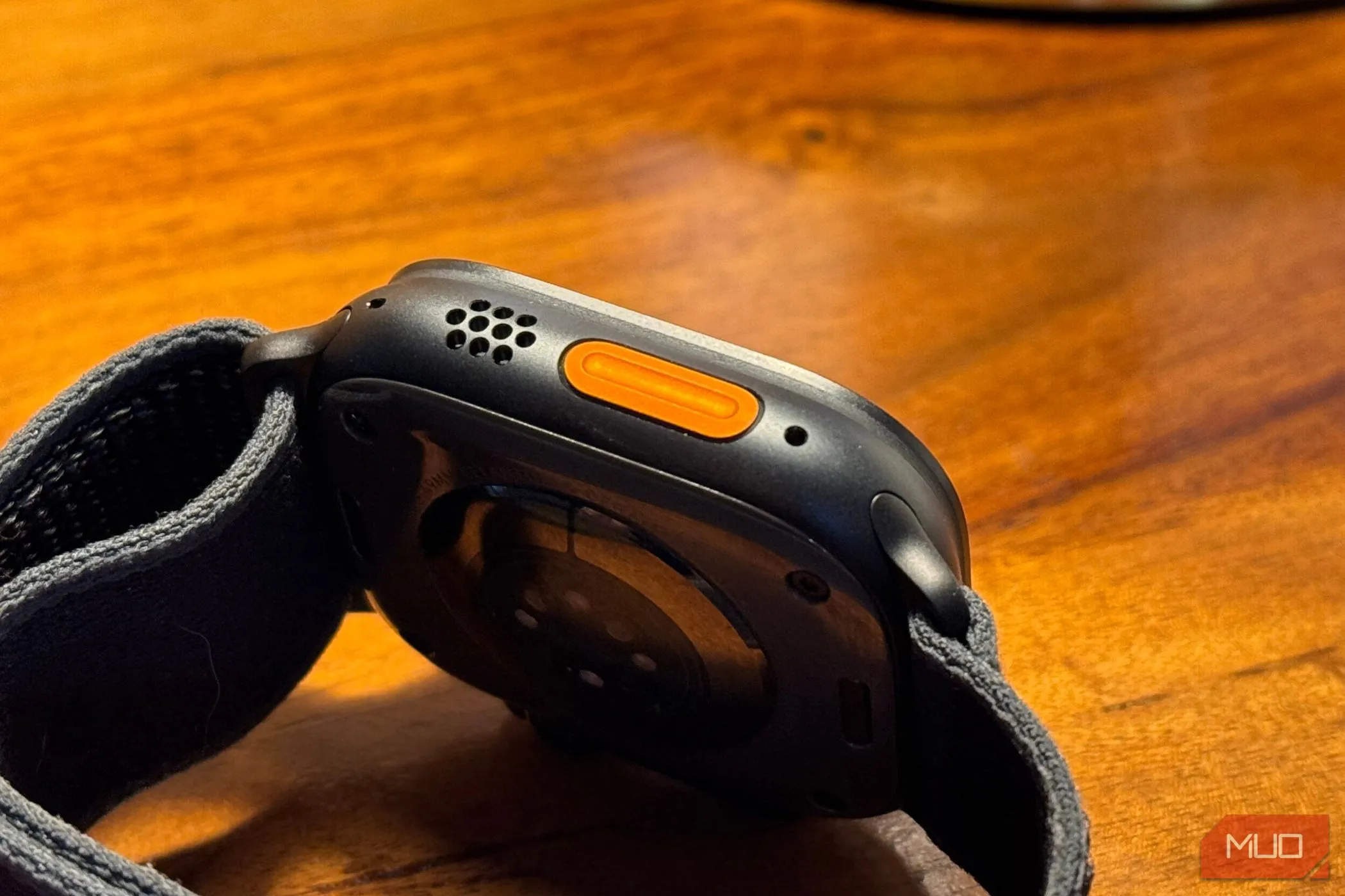 Nút Action Button trên Apple Watch Ultra 2 màu titan đen đặt trên bàn