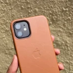Ốp lưng da màu nâu cho iPhone 12 đang được cầm trên tay, thể hiện vẻ ngoài cao cấp và bền bỉ của phụ kiện Apple trước đây.