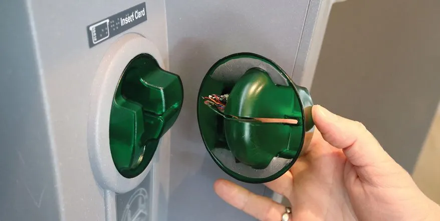 So sánh thiết bị skimming thẻ với đầu đọc thẻ tín dụng thật tại cây ATM.