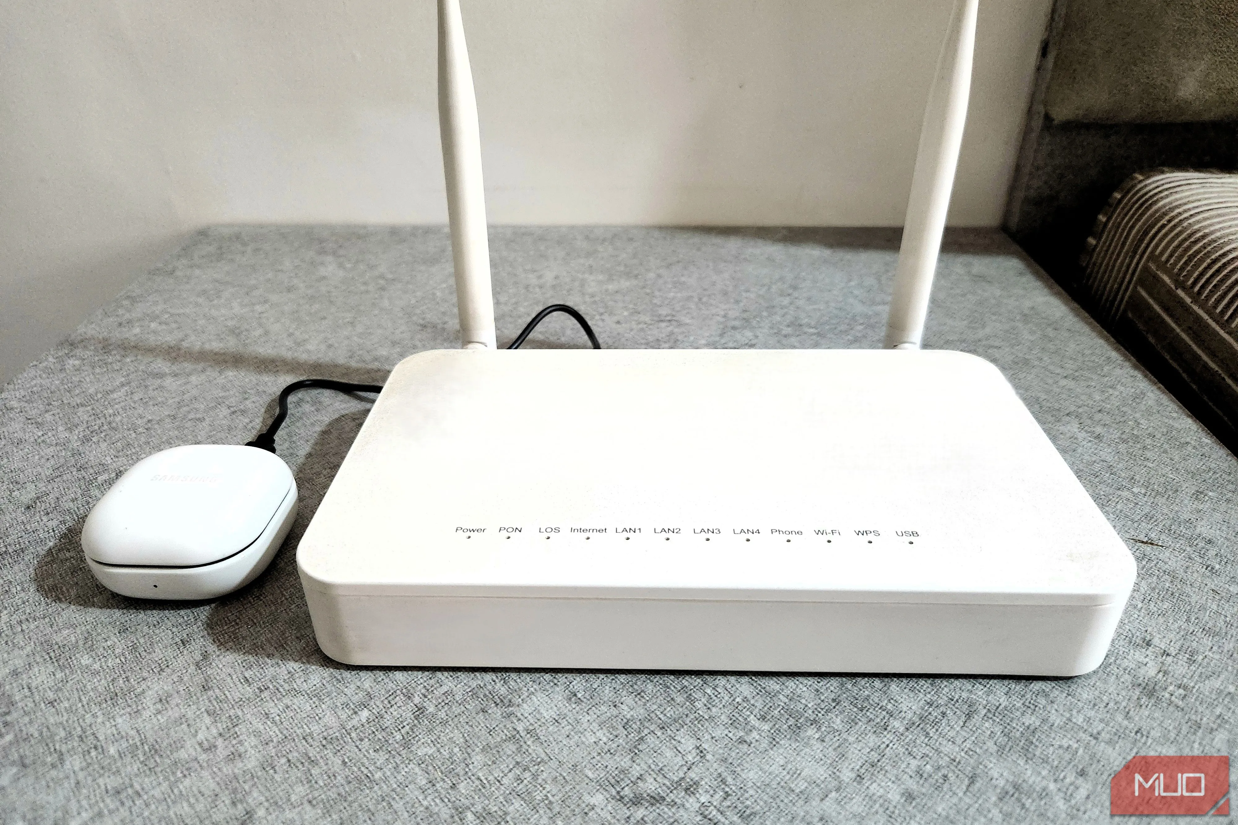 Tai nghe Bluetooth đang sạc qua cổng USB của router tiện lợi