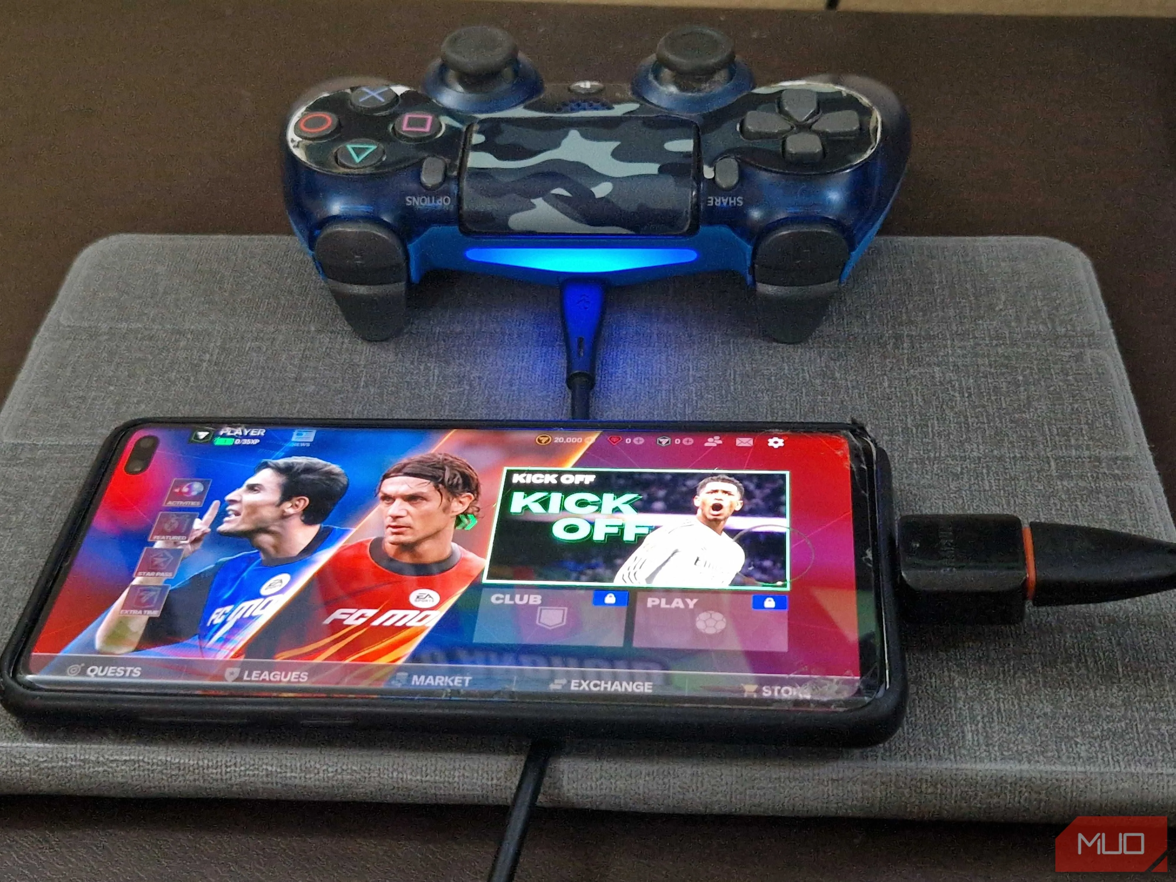 Tay cầm PS4 cắm vào smartphone qua bộ chuyển đổi OTG và cáp USB.