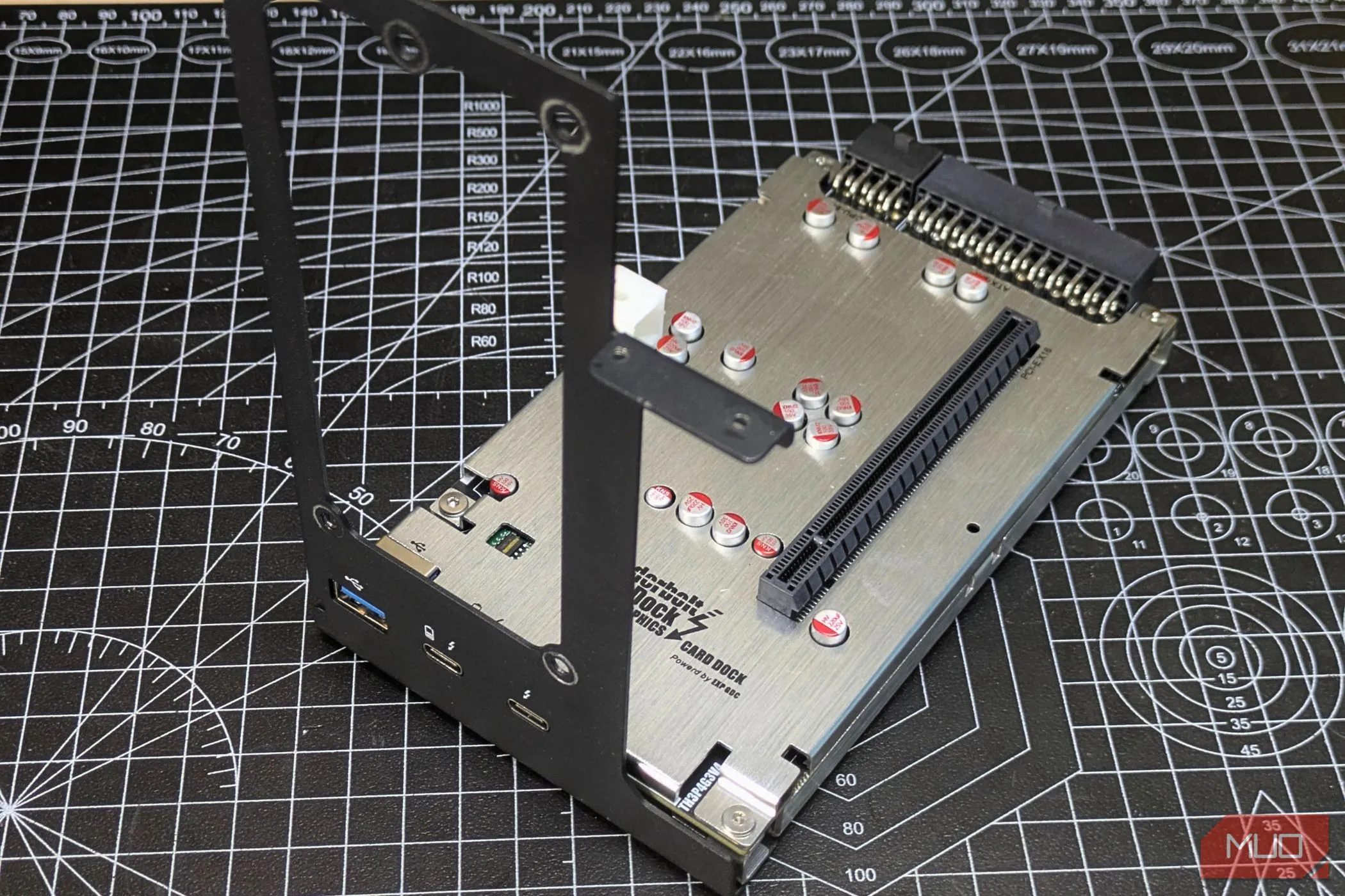 Thao tác gắn giá đỡ (mounting bracket) vào dock eGPU TH3P4, bước đầu tiên trong quá trình lắp ráp.