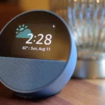Amazon Echo Spot màu xanh đặt trên bàn gỗ, minh họa thiết bị Alexa thu thập dữ liệu giọng nói lên đám mây.