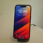 Điện thoại iPhone 14 Pro đang sạc không dây trên bộ sạc UGreen màu xám