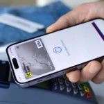 Một người đàn ông đang sử dụng Apple Pay trên iPhone để thanh toán tại cửa hàng